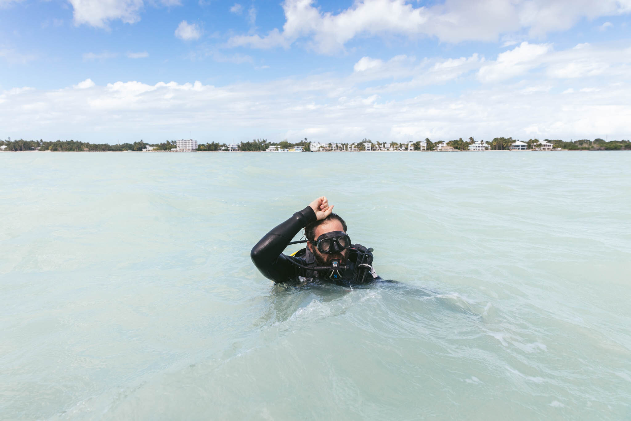  Man In Scuba Gear About To Dive Under The Crystal Clear Florida Waters Of The Atlantic Ocean Off The Islands Of Islamorada’s Private Beach. 