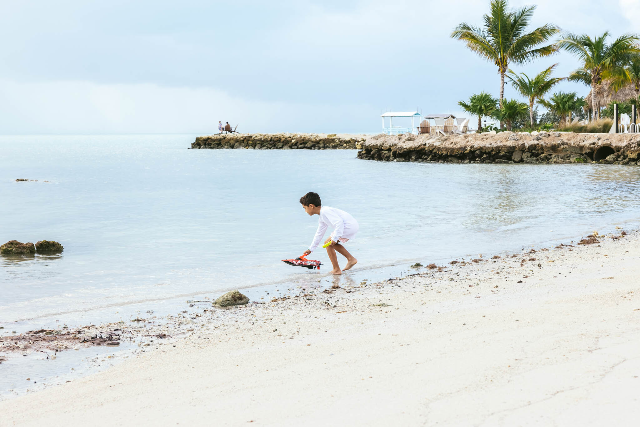  Young boy playing with a toy boat on The Islands of Islamorada’s private beach. 