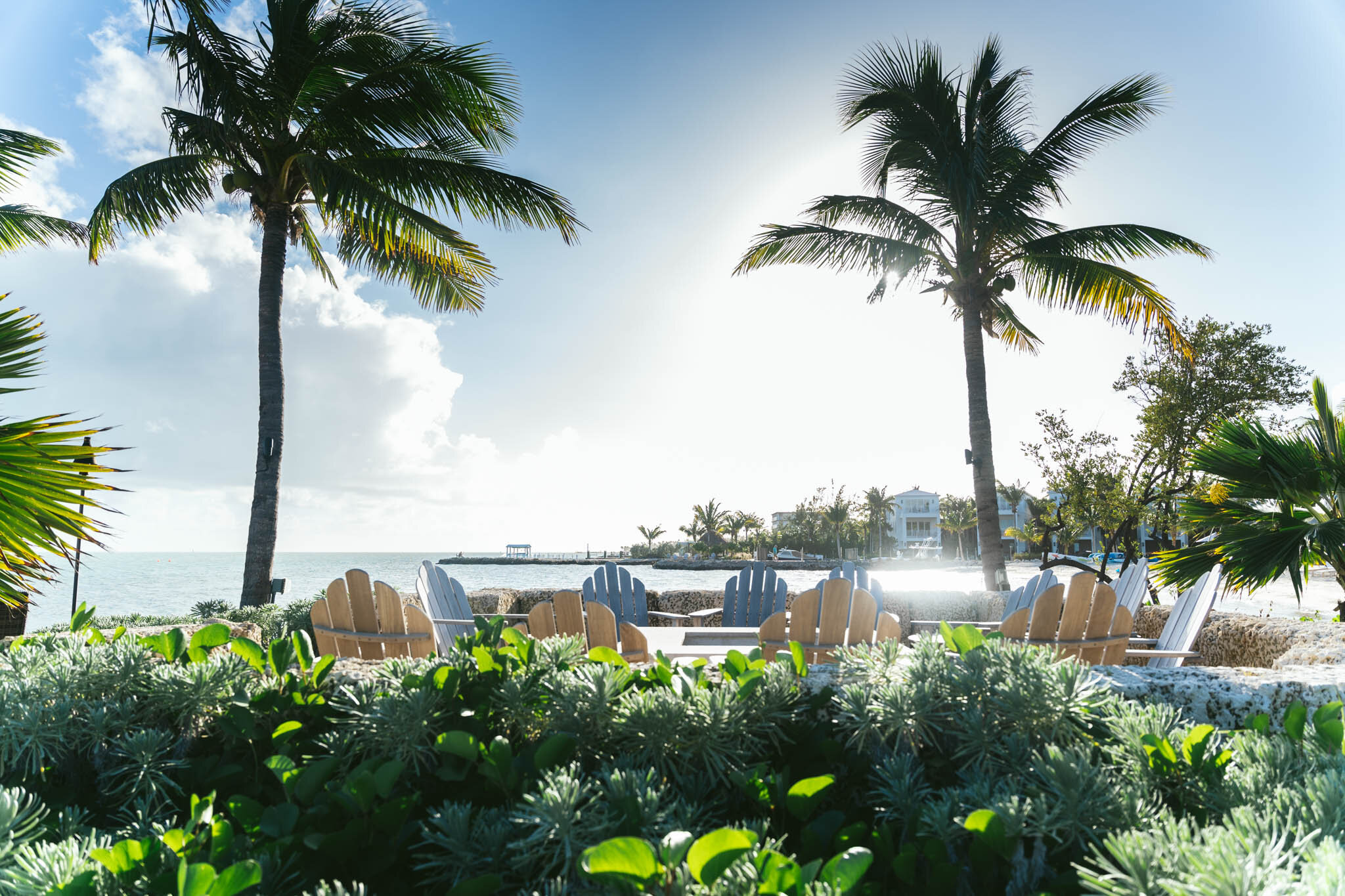  Palm trees surround The Islands of Islamorada’s beachside fire pit as the sun shines over the Atlantic Ocean in the background. 