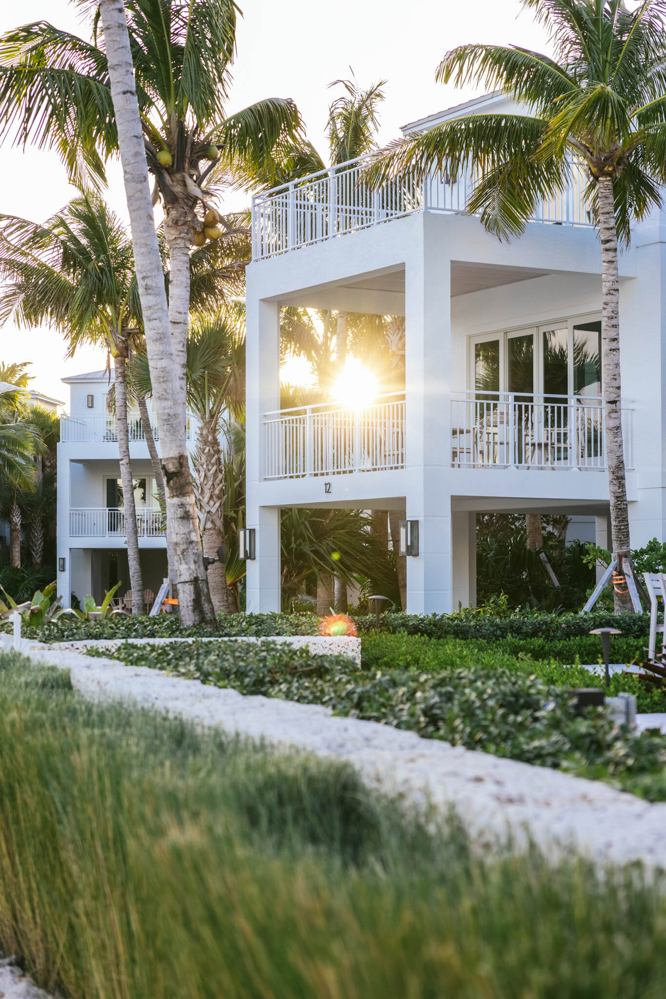  The sun peeks through a palm tree behind the balcony of a waterfront villa at The Islands of Islamorada. 