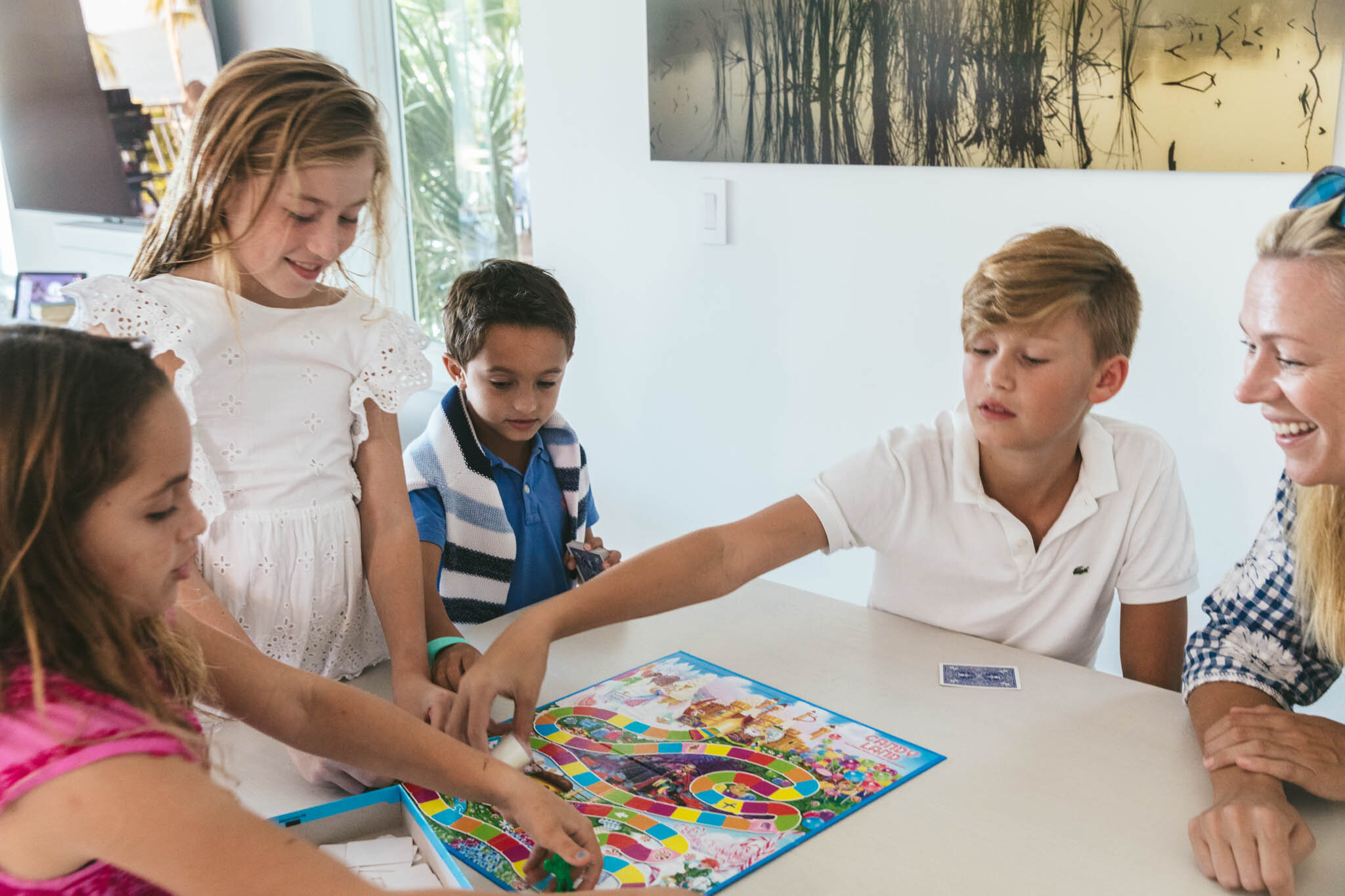  Group of kids play a game of Candy Land in the living room of an Islands waterfront villa. 