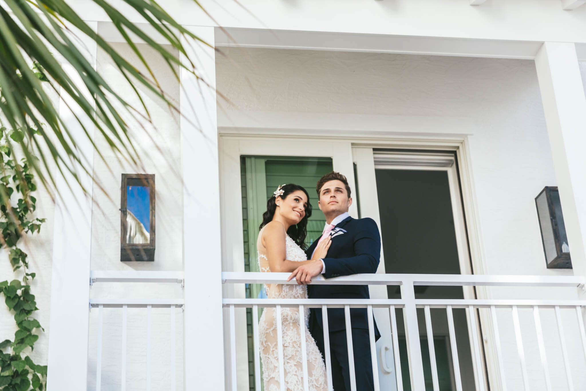  Bride and groom standing together on the covered balcony of an  Islands of Islamorada waterfront villa. 