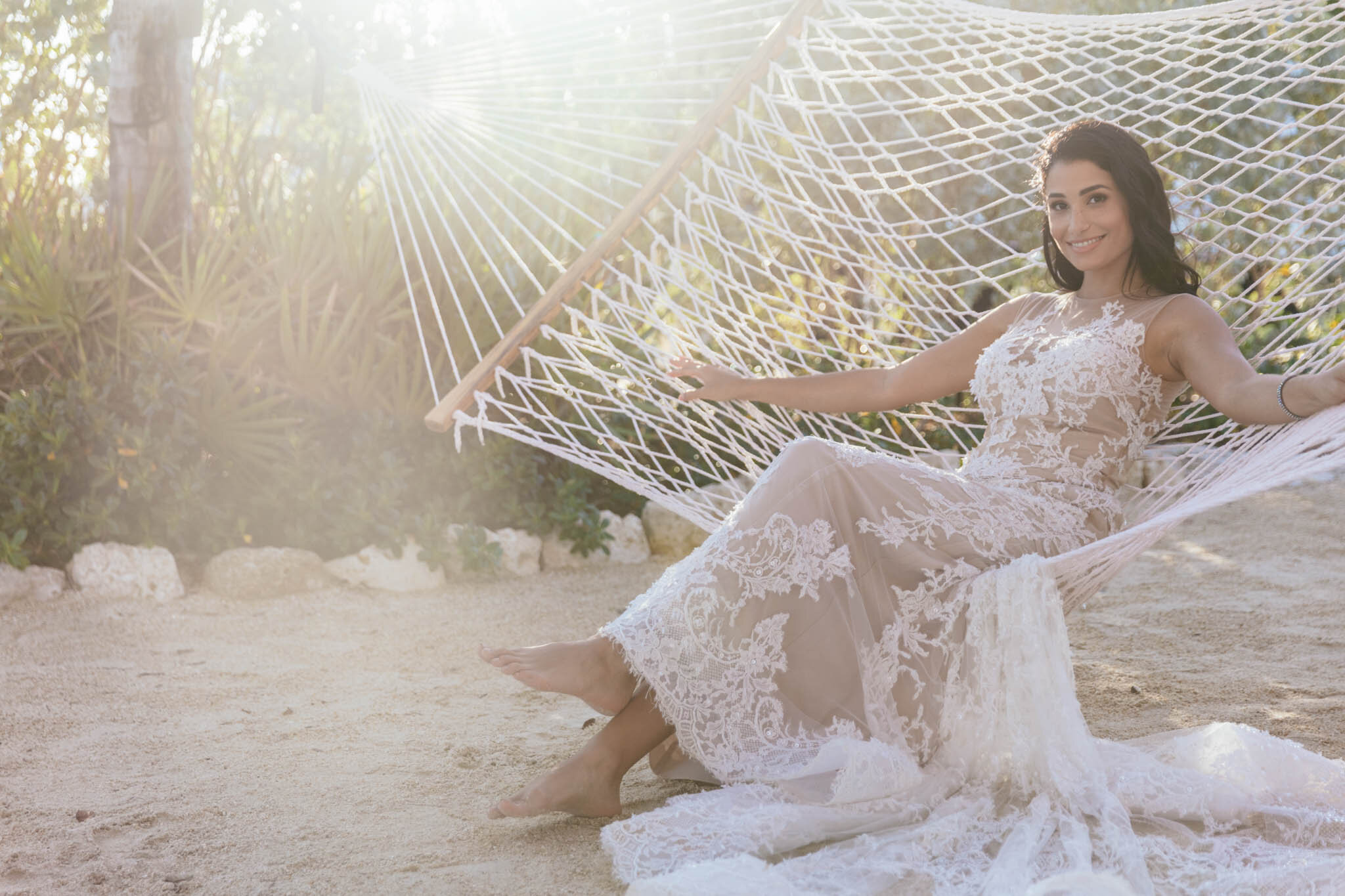  Bride in her wedding dress sitting on a hammock on The Islands of Islamorada’s private beach. 