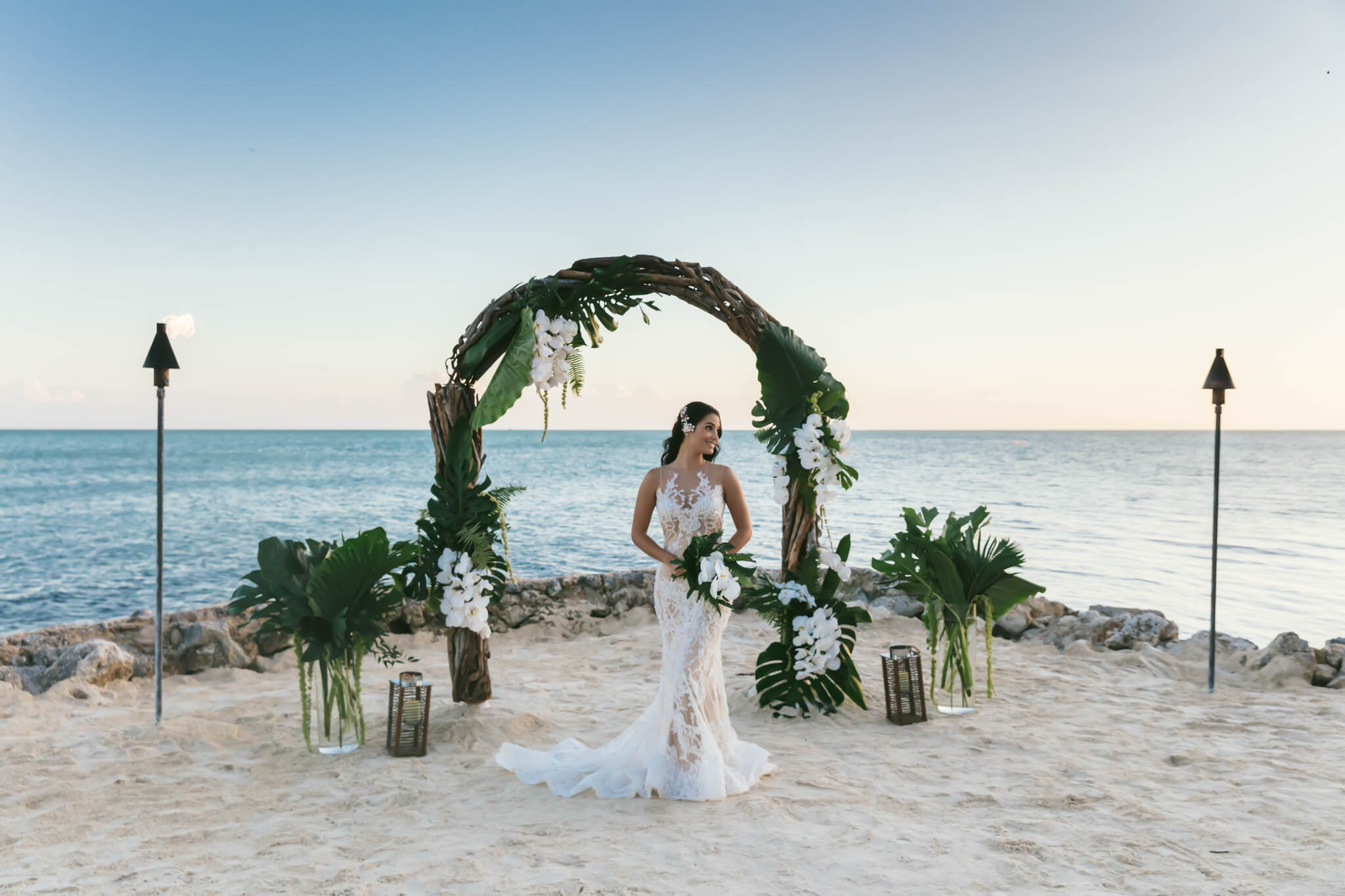  Bride stands under a wedding arch on The Islands of Islamorada’s private jetty with the Atlantic Ocean as a backdrop. 