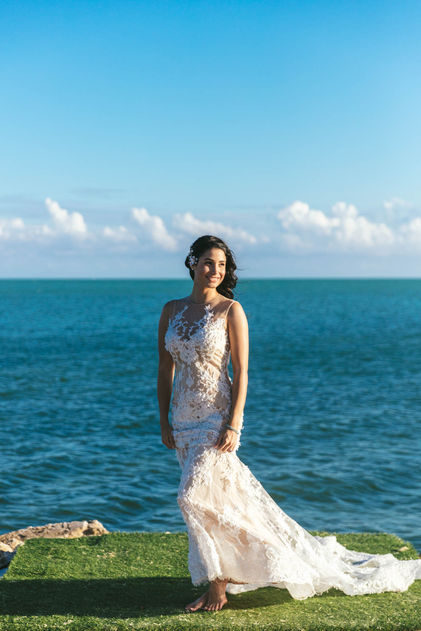  Bride in her wedding dress stands on the edge of The Islands of Islamorada’s private jetty with the Atlantic Ocean as a backdrop. 