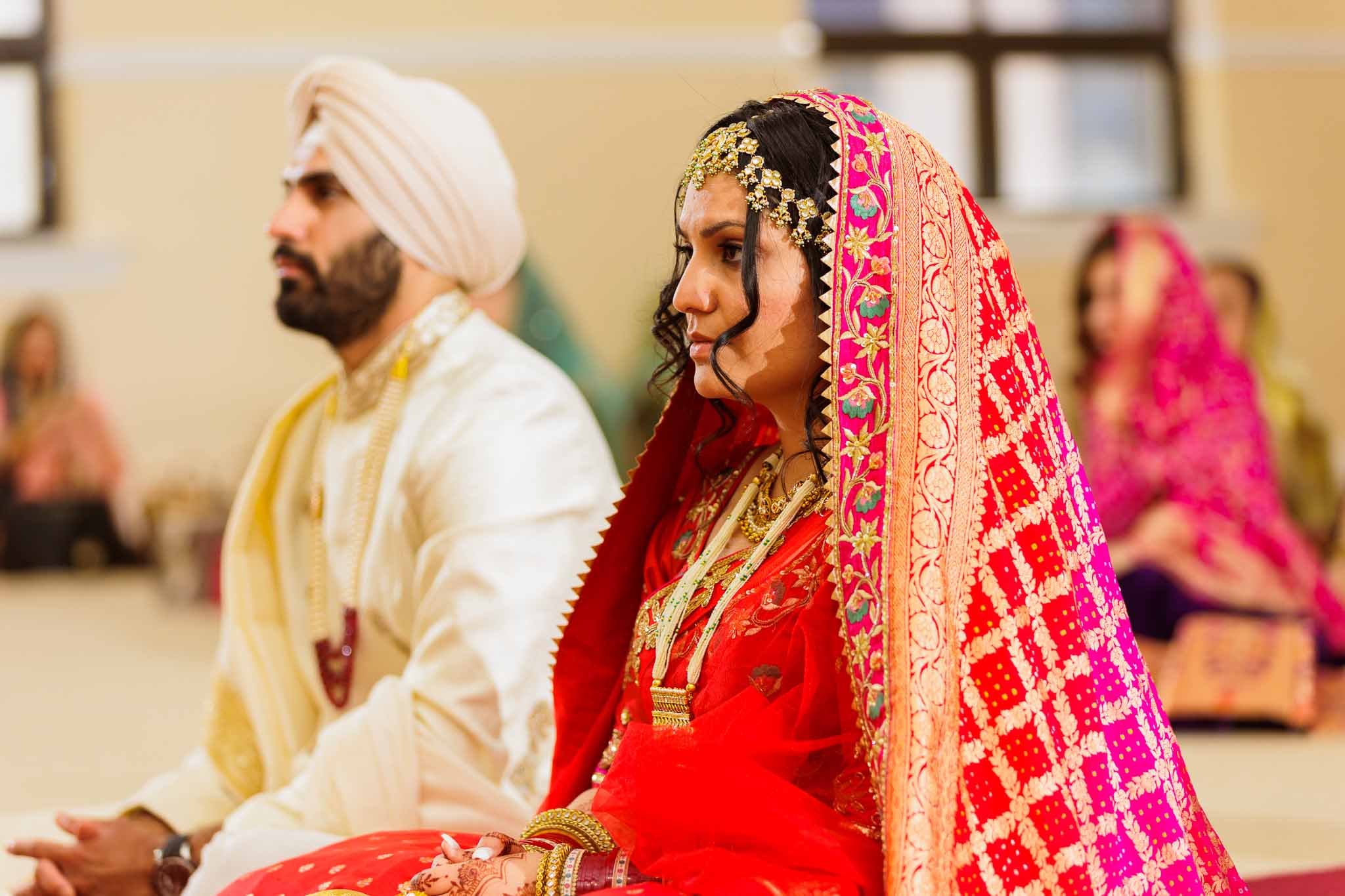 A Punjabi bride and groom getting married with traditional rituals in Gurudwara