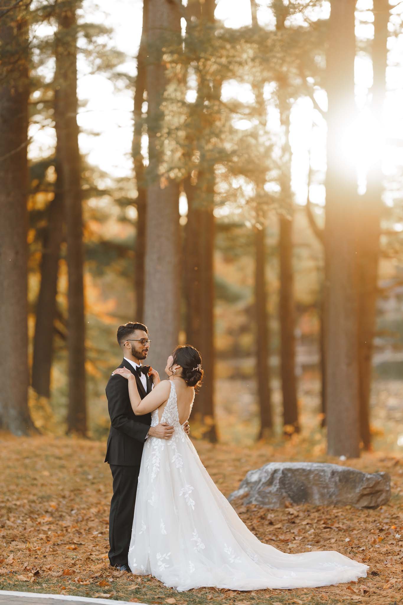 Bride and Groom posing for their portraits on their wedding day during sunset hours in fall