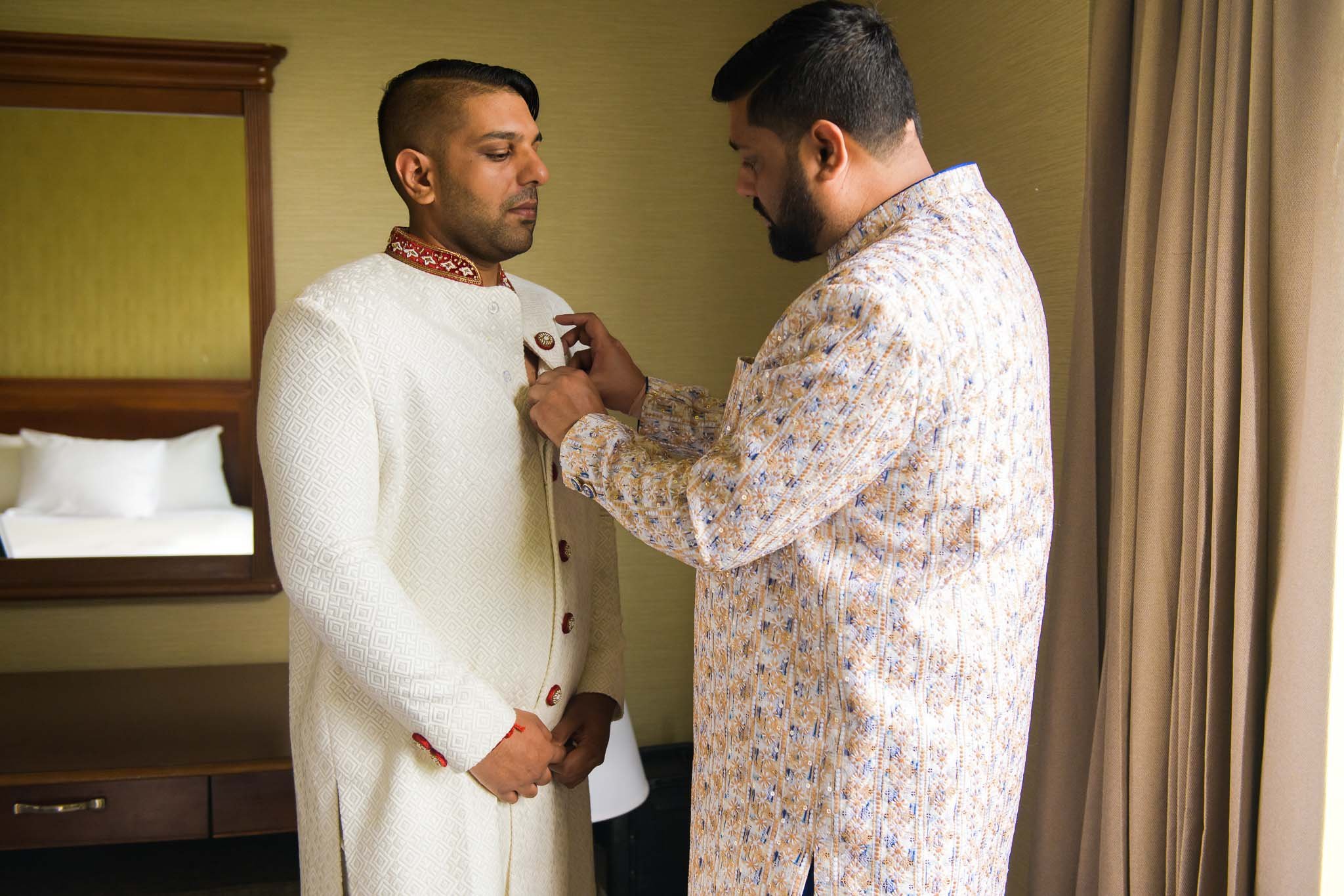  Indian groom getting ready on his wedding day with help of his brother 