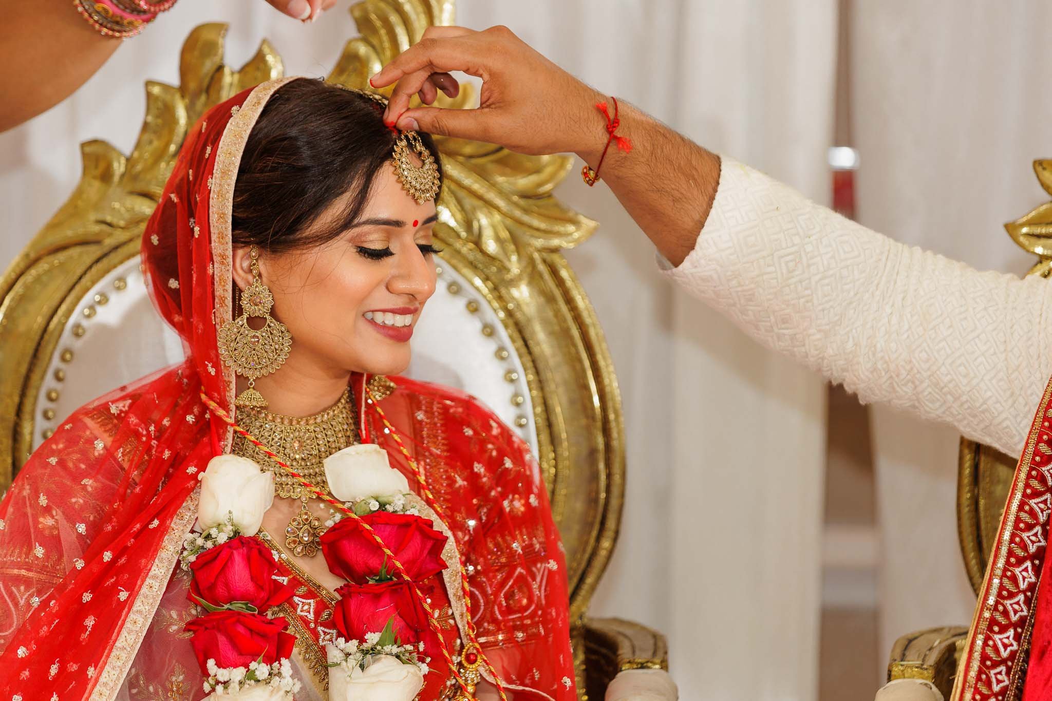  Indian bride adorned with Sindur, a red powder that symbolizes her marriage status 