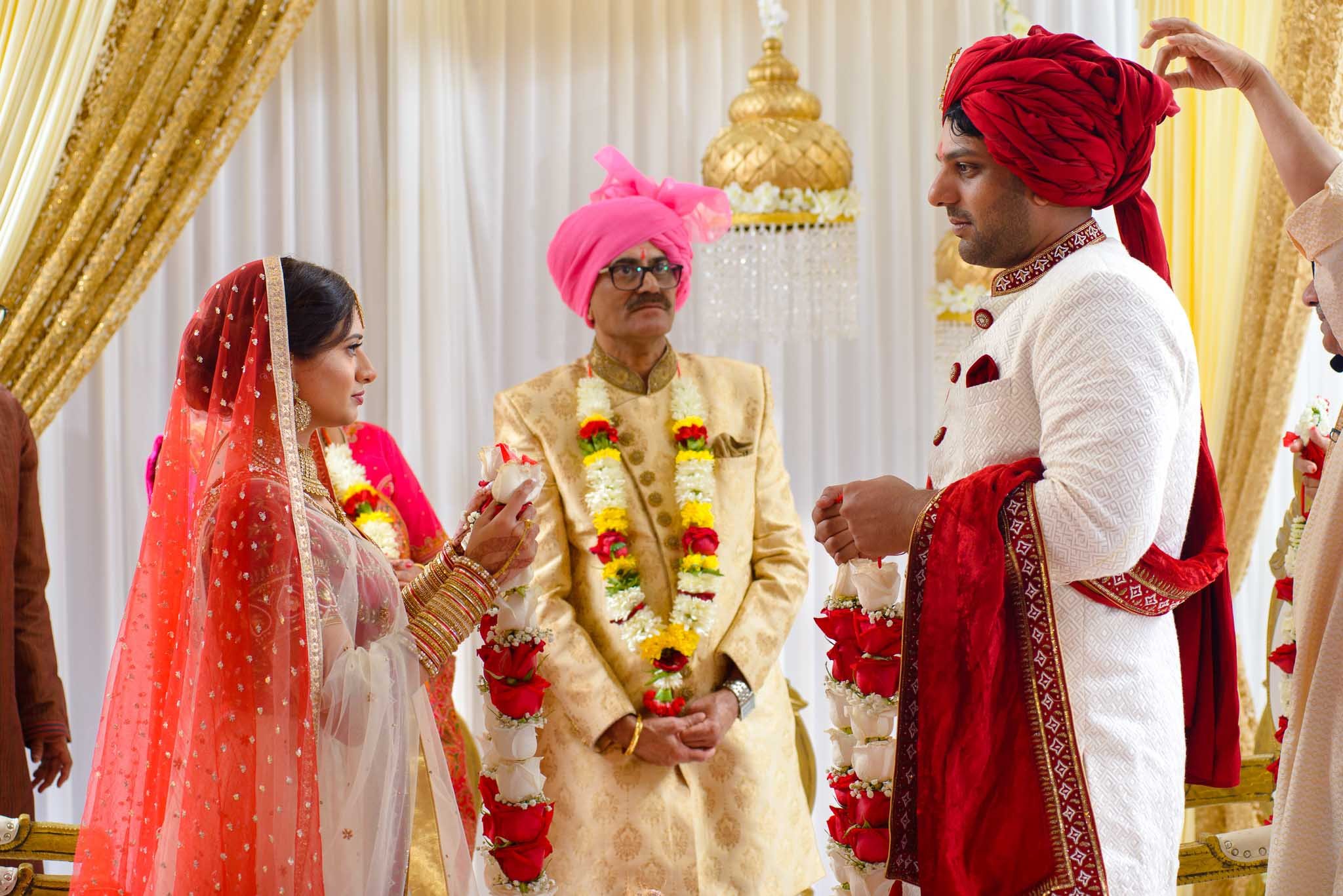  Indian bride and groom exchanging garlands during wedding ceremony 