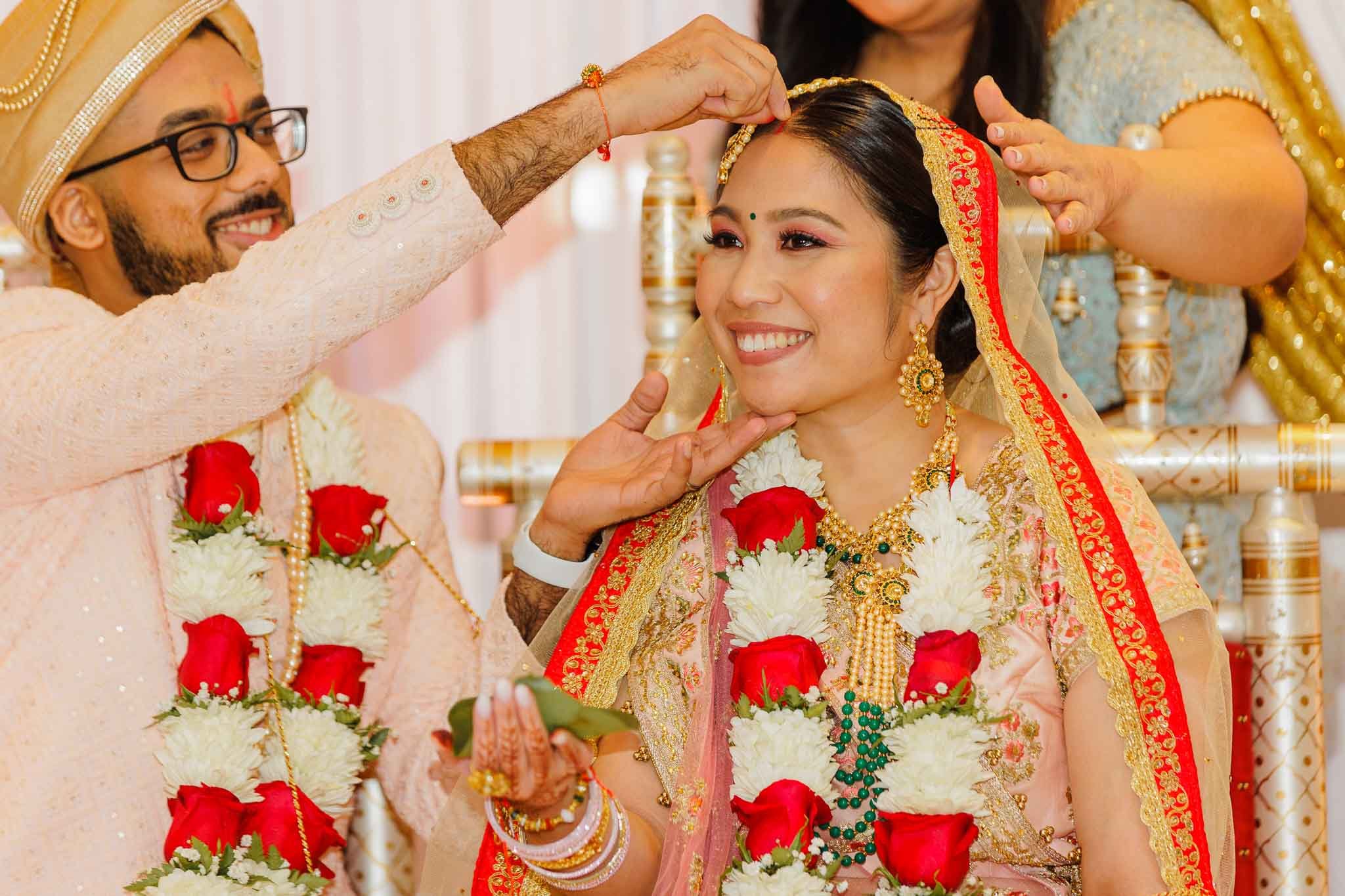 Indian groom putting Sindur to his Bride