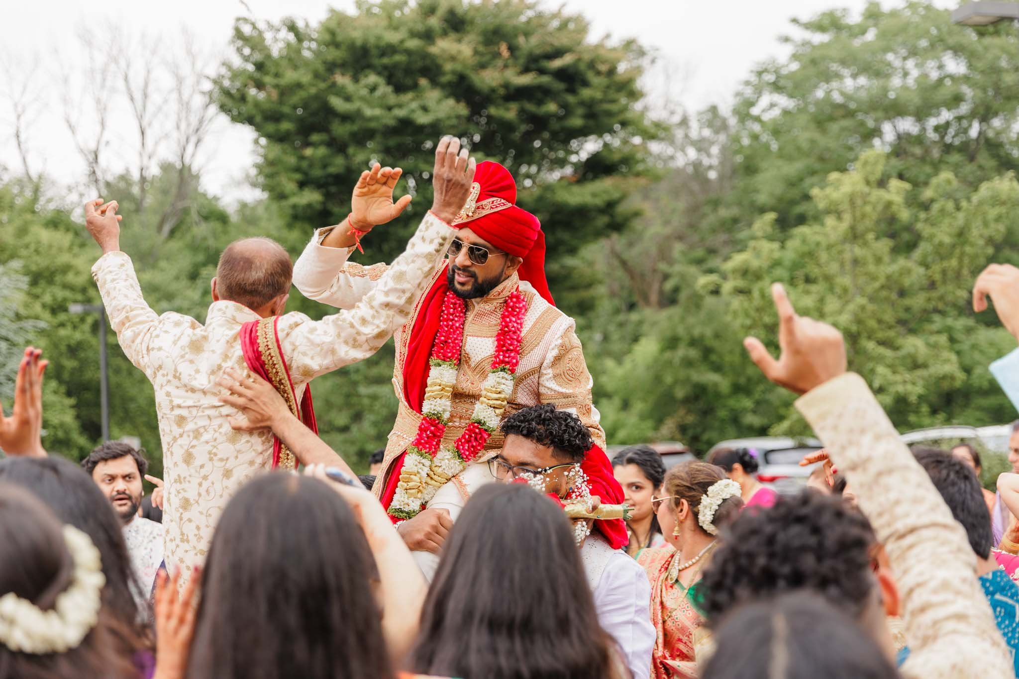 Indian groom and family dancing during baraat