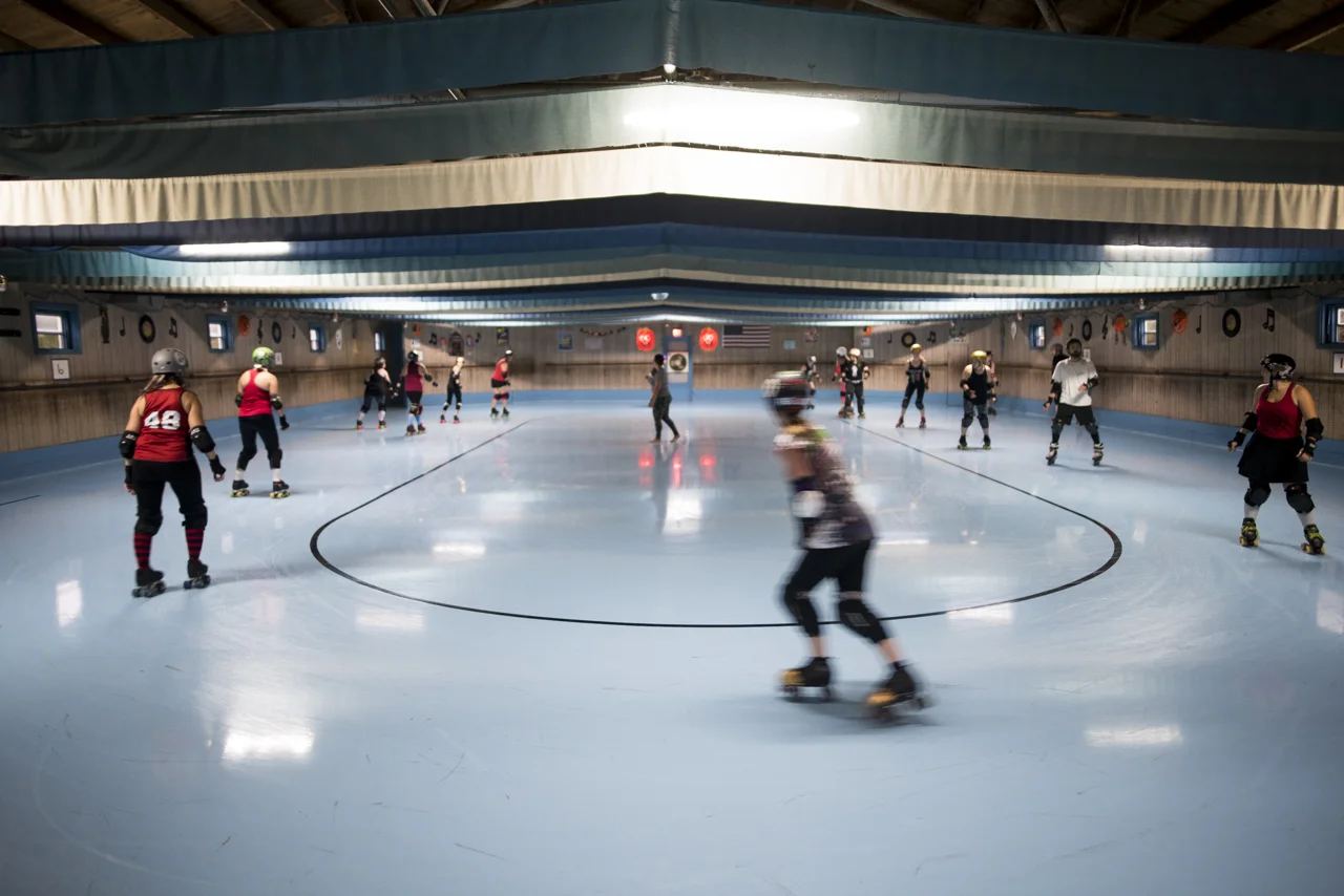Members of the Appalachian Hellbetties skate laps to warm up for practice at the Dow Roller Arena in Athens Ohio.