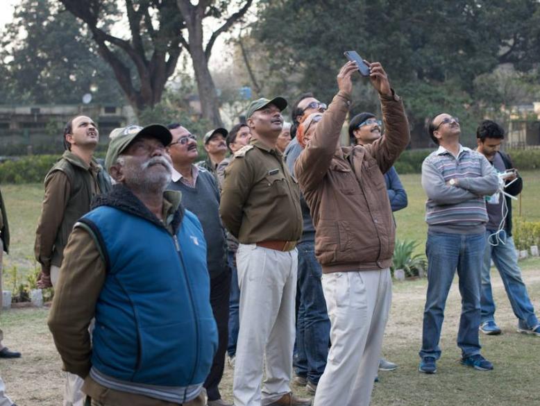 Forest Department staff watching a drone in flight.