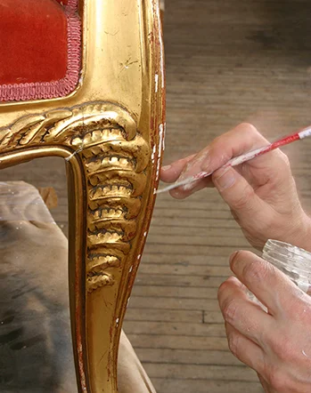 Applying a layer of gesso to damaged areas