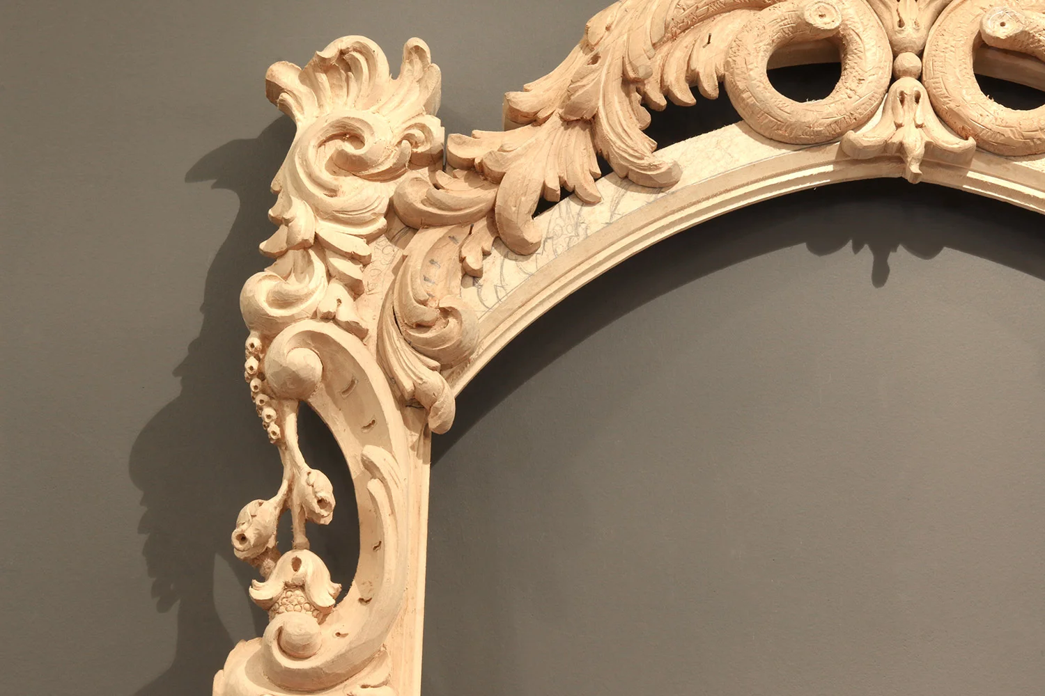 The corner in the photo above is transformed into an elaborate carving. The carver will continue rendering the design arrangement of stylized acanthus and scroll work following pencil drawing as well as integrating further detail into the solid wood.