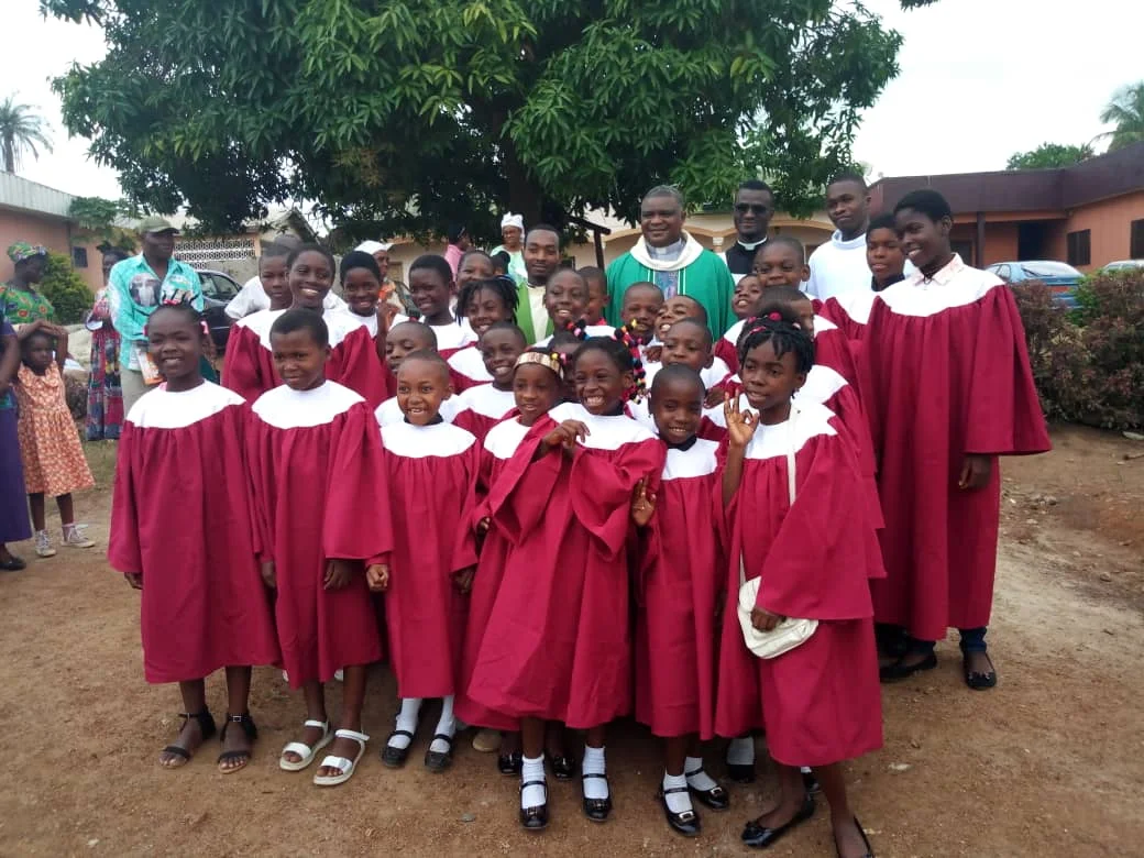 The photo shows Fr. Bienvenu after Mass at the Cathedral of his diocese together with the children’s choir.