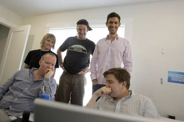 BRAINSTORMING: FunnyorDie head of production Mike Farah, standing at right, with cap-wearing writer-actor Seth Morris and other staffers. (Photo courtesy of Gary Friedman, Los Angeles Times)