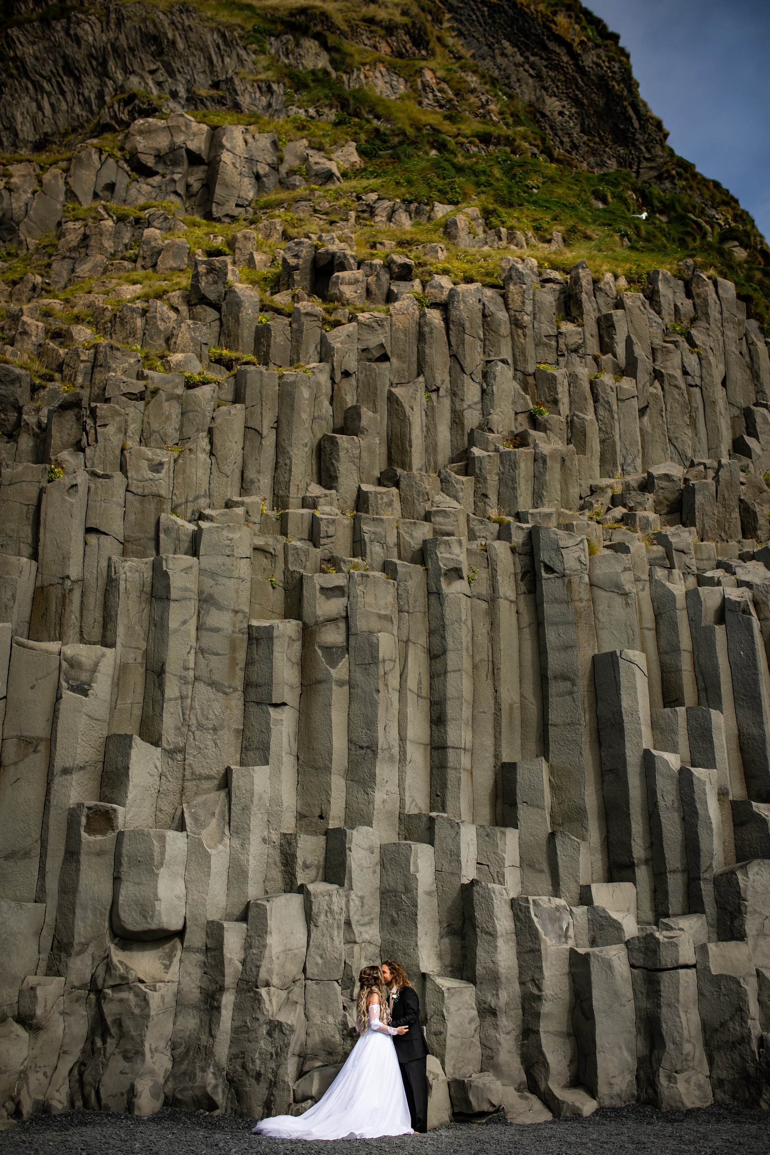 bride & groom kissing in front of basalt columns in Iceland