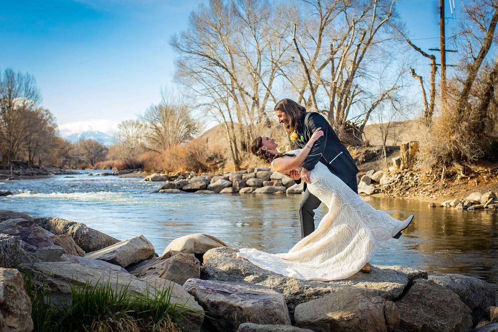 groom dipping bride next to the river Salida colorado