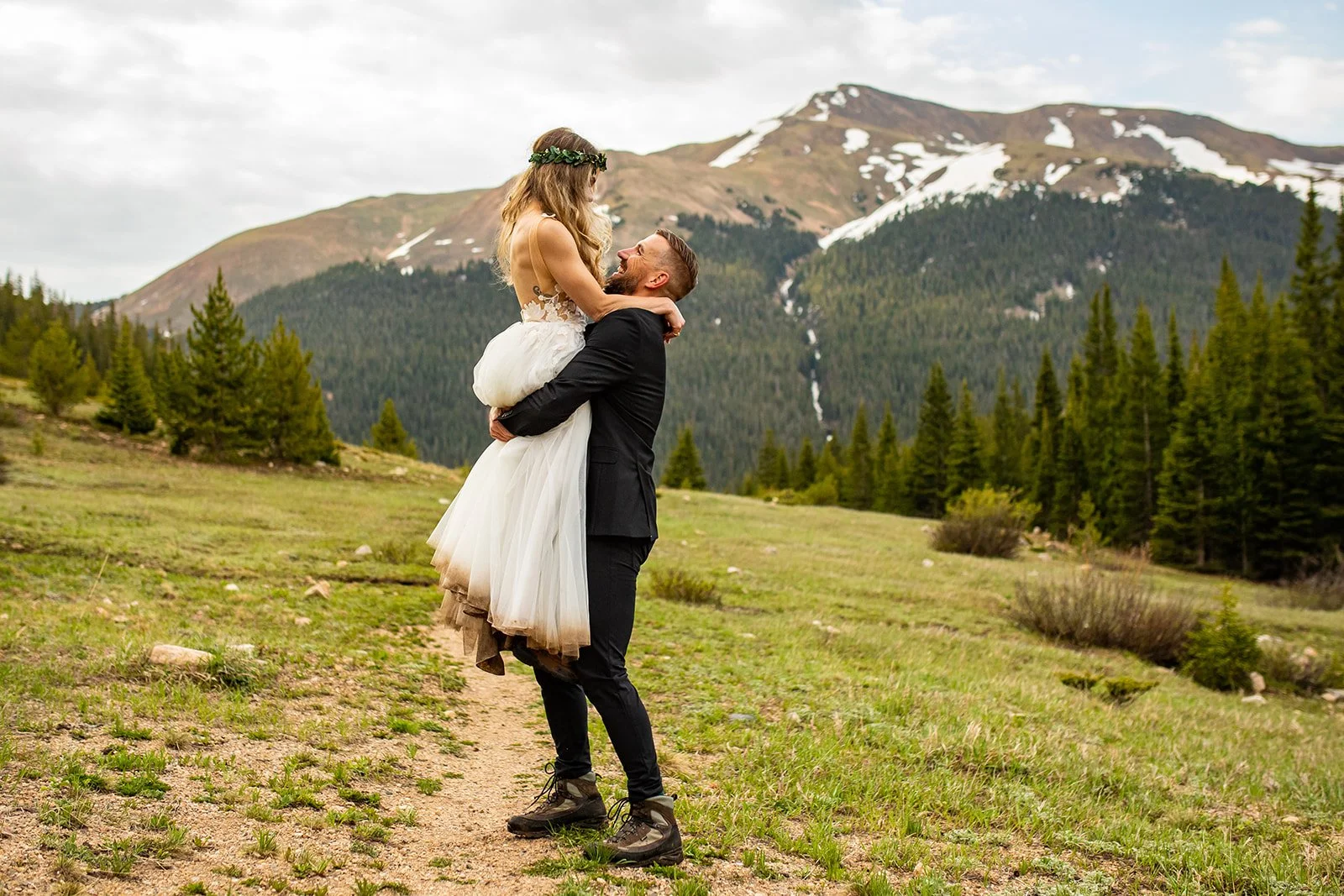 groom lifting bride with mountains in the background