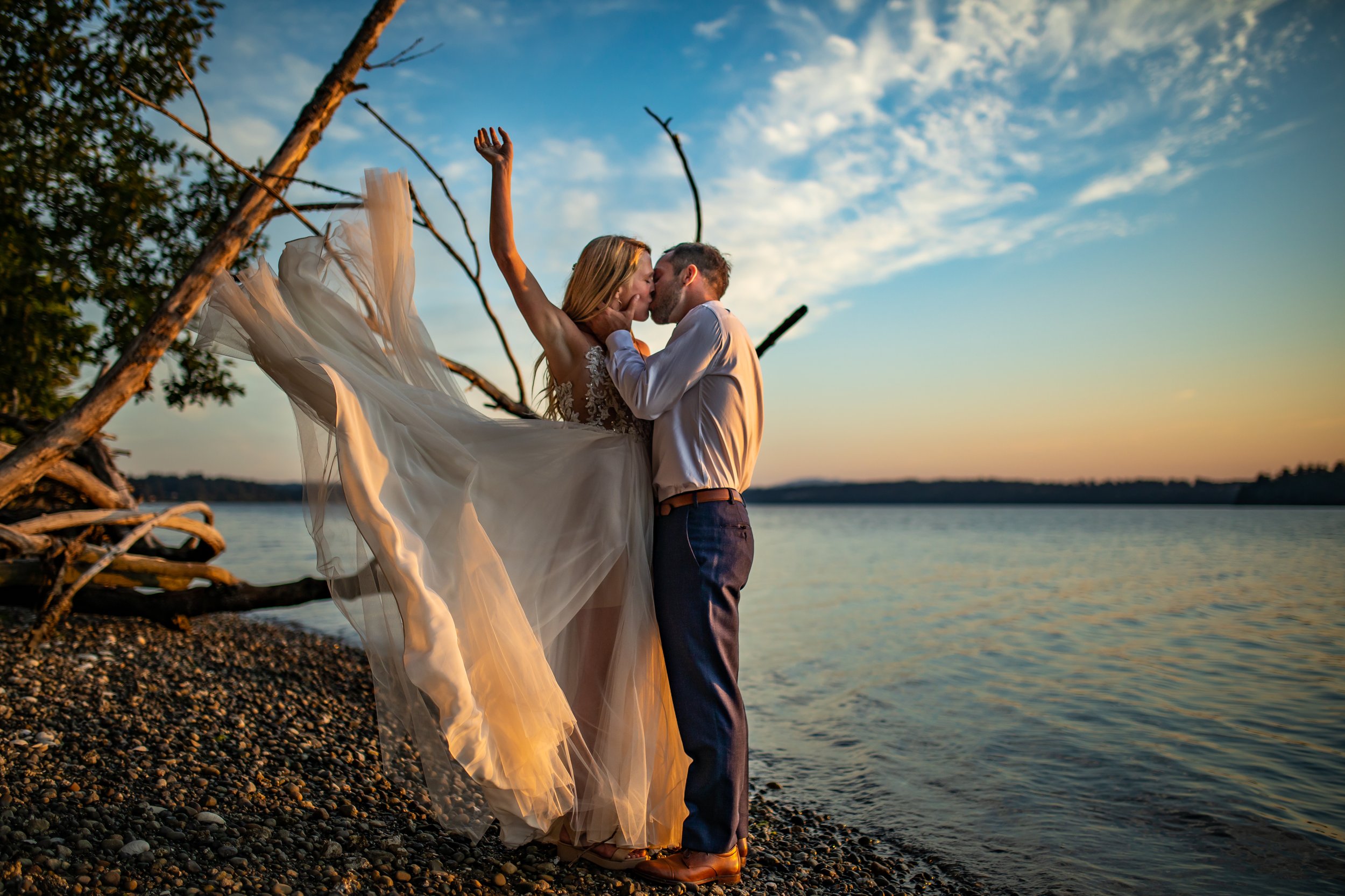 newlyweds kissing on beach during sunset