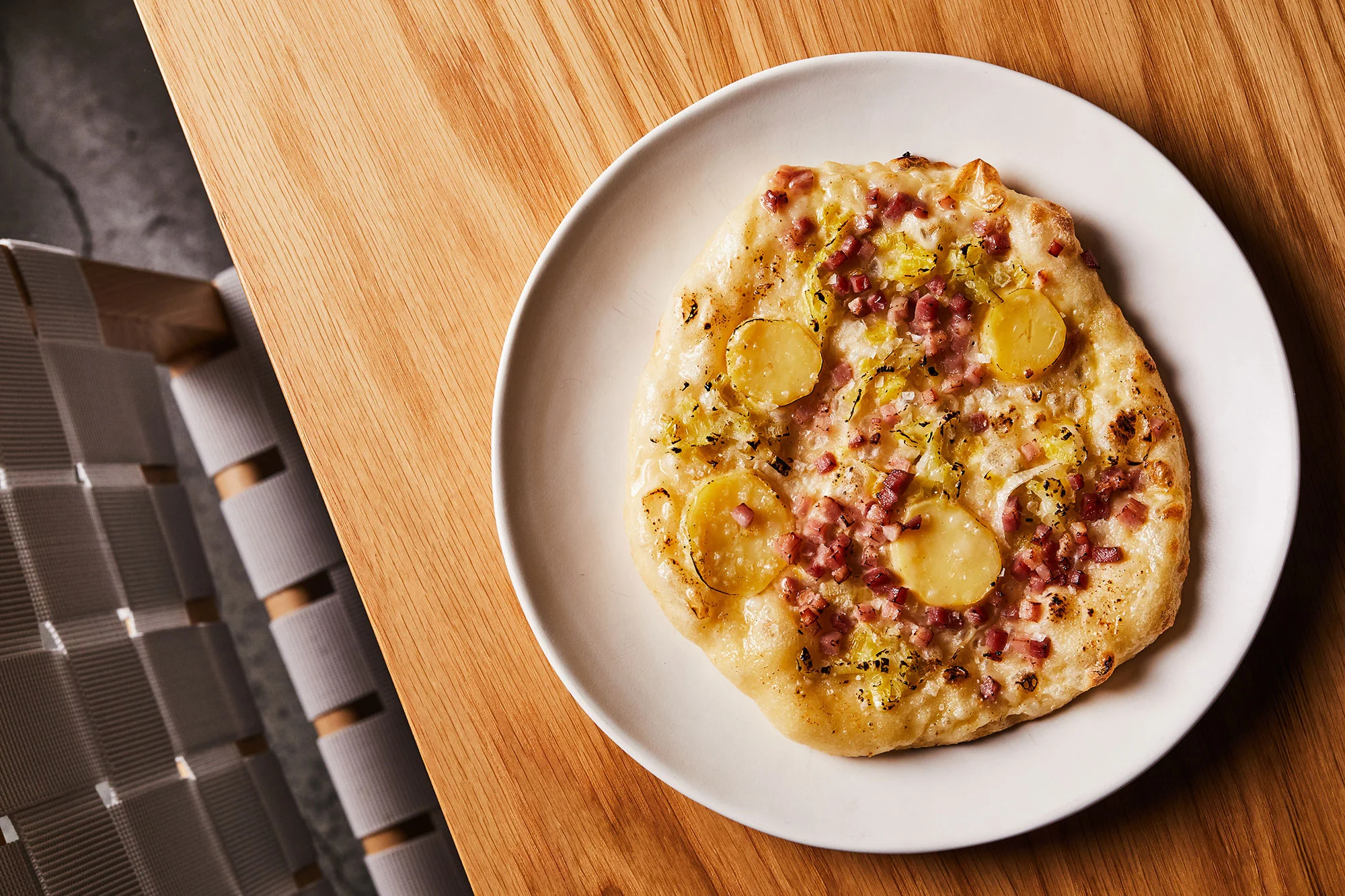 Wood-fired flatbread with crème fraîche, potato, speck and leek