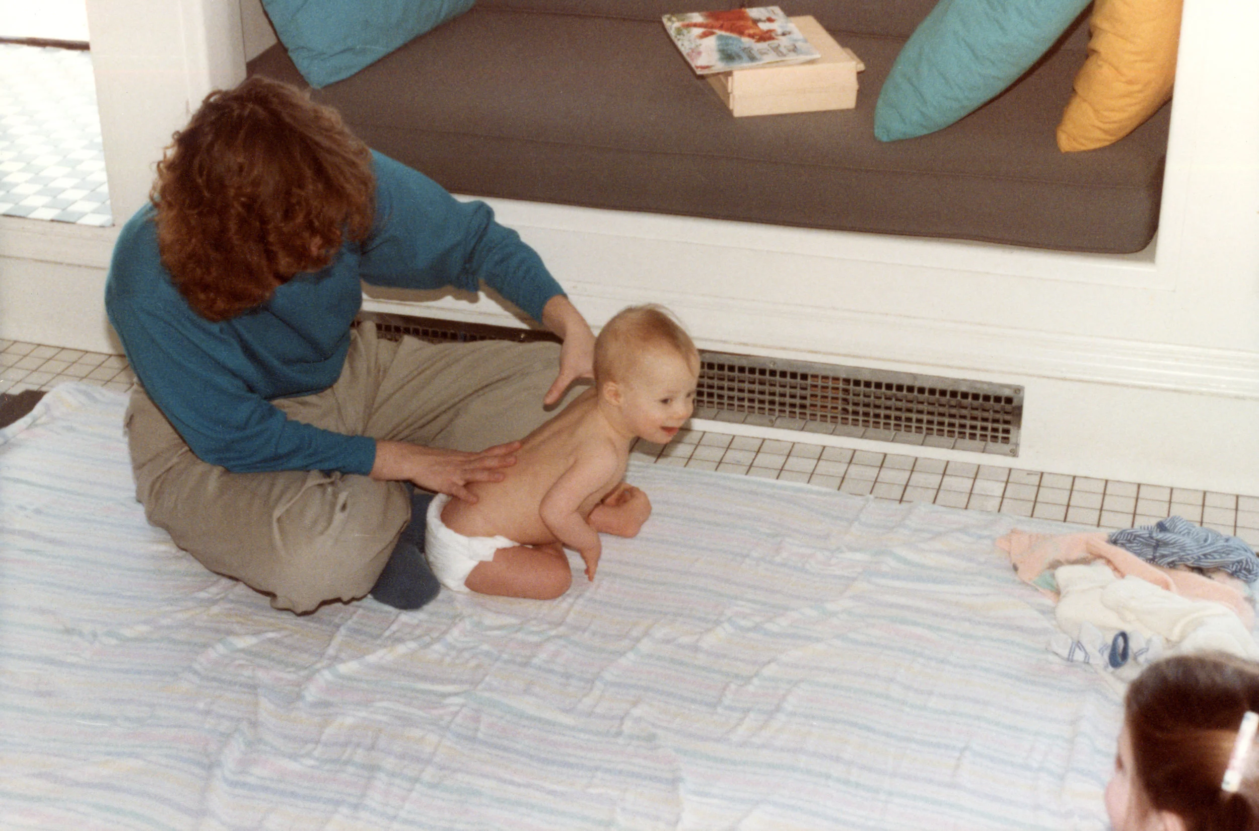 Nicholas Miller in a physical therapy session on the kitchen floor, Helen looking on. Therapist unknown. Photo by Patricia Nooy (1984)
