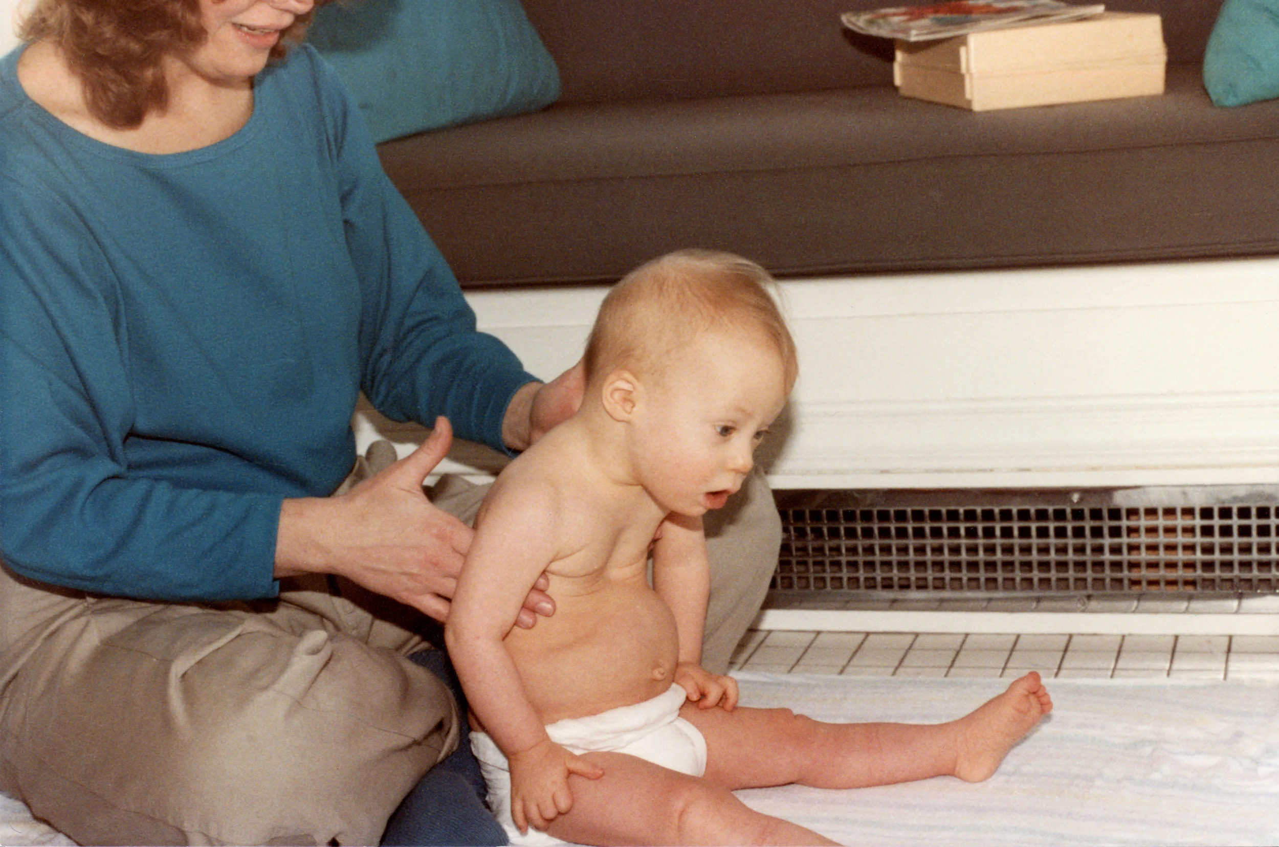 Nicholas Miller in a physical therapy session on the kitchen floor, Helen looking on. Therapist unknown. Photo by Patricia Nooy (1984)