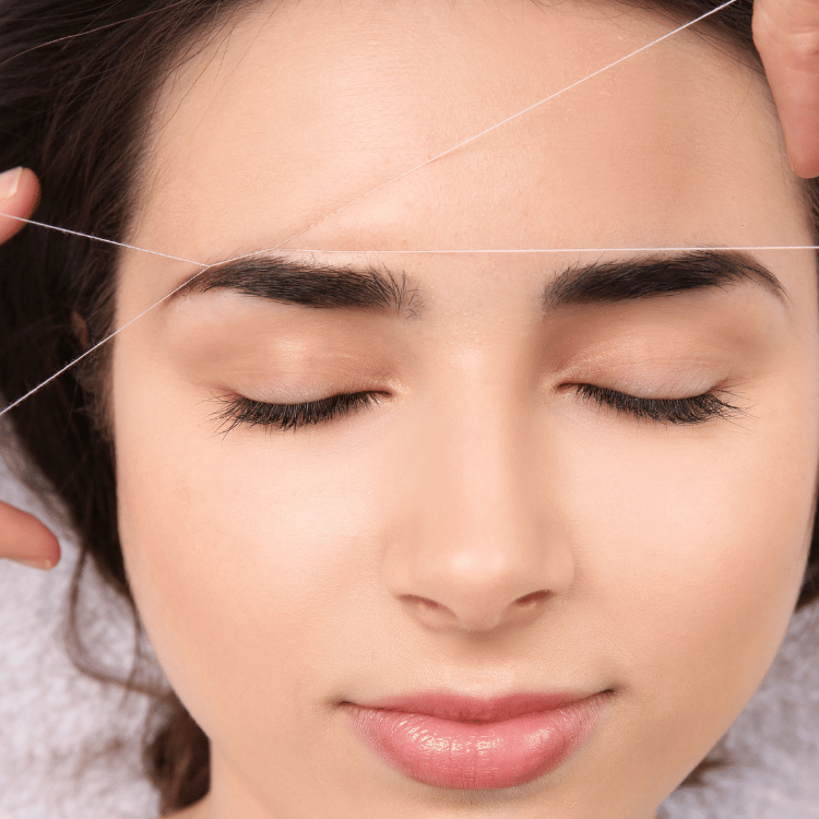 Woman threading eyebrows