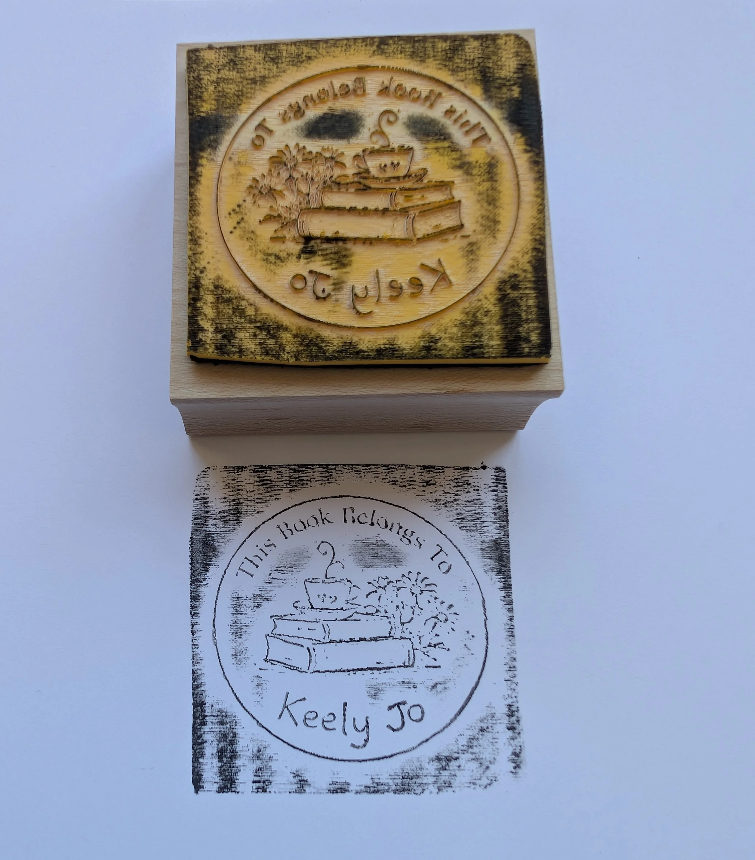 Laser-engraved rubber stamp showing ink coating the shallow background, resulting in a muddy filled-in impression on paper