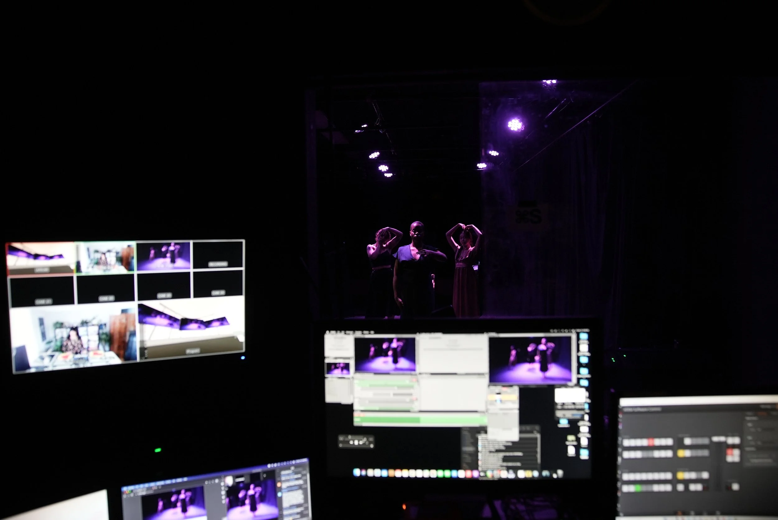 computer screens frame dancers far away in a black box studio. photo by carlos cardona.