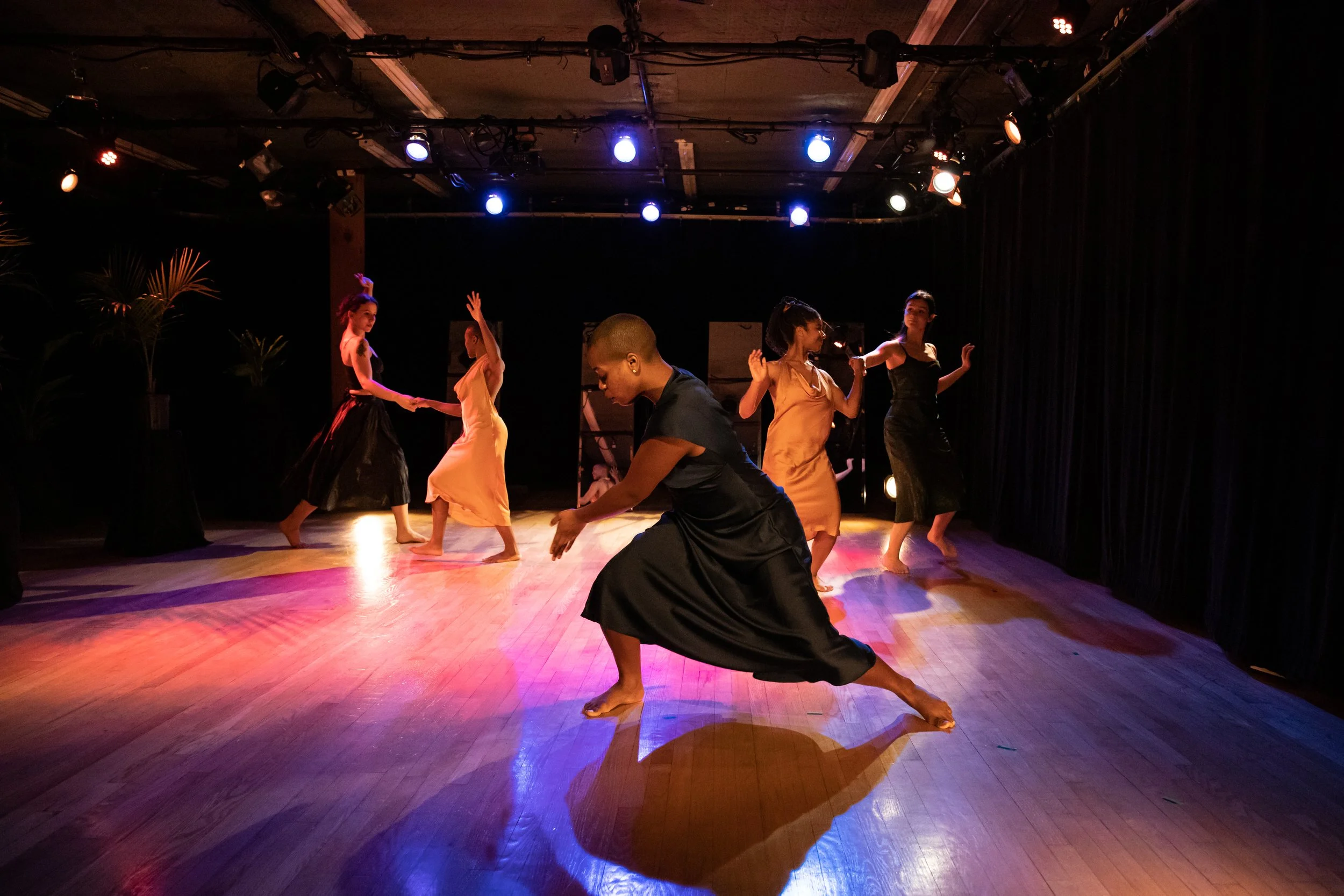 tri dances downstage as four dancers waltz upstage.