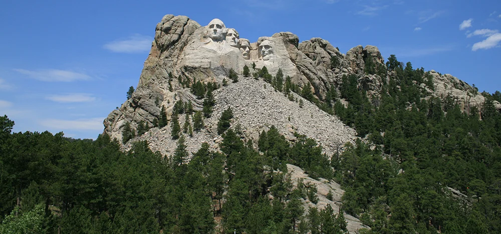 Mount Rushmore from the highway, the moment the road turns to face it directly.