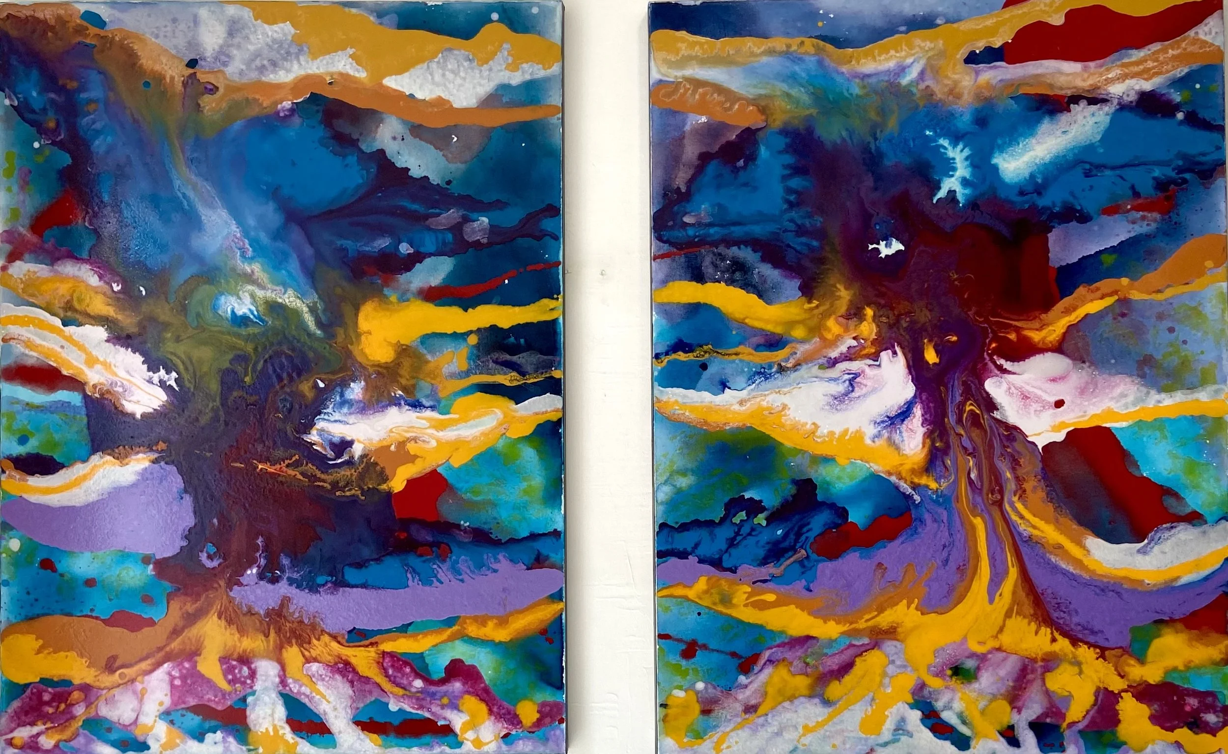 Two colorful abstract paintings with vibrant splashes of blue, purple, orange, yellow, green, red, and white, resembling explosive or volcanic scenes.
