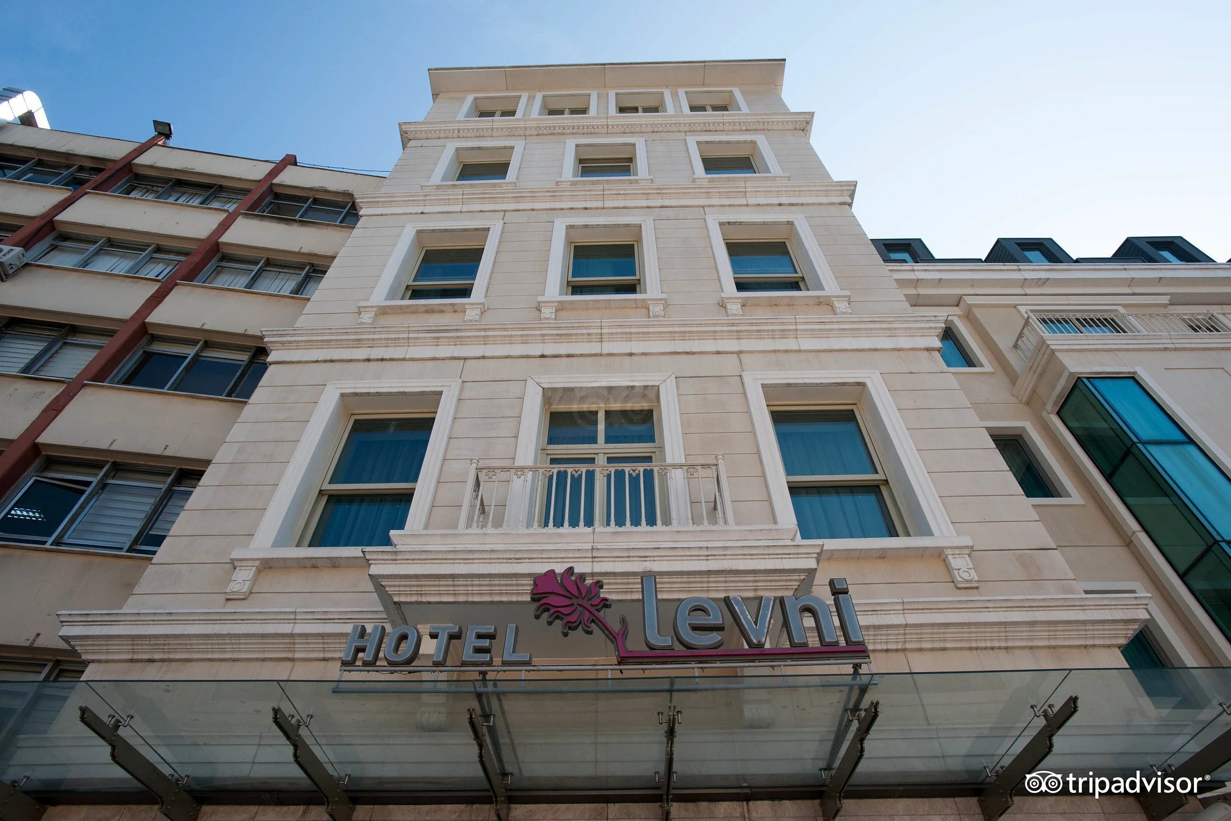 Concrete building with the words Levni Hotel in  blue letters over the entrance to the building.