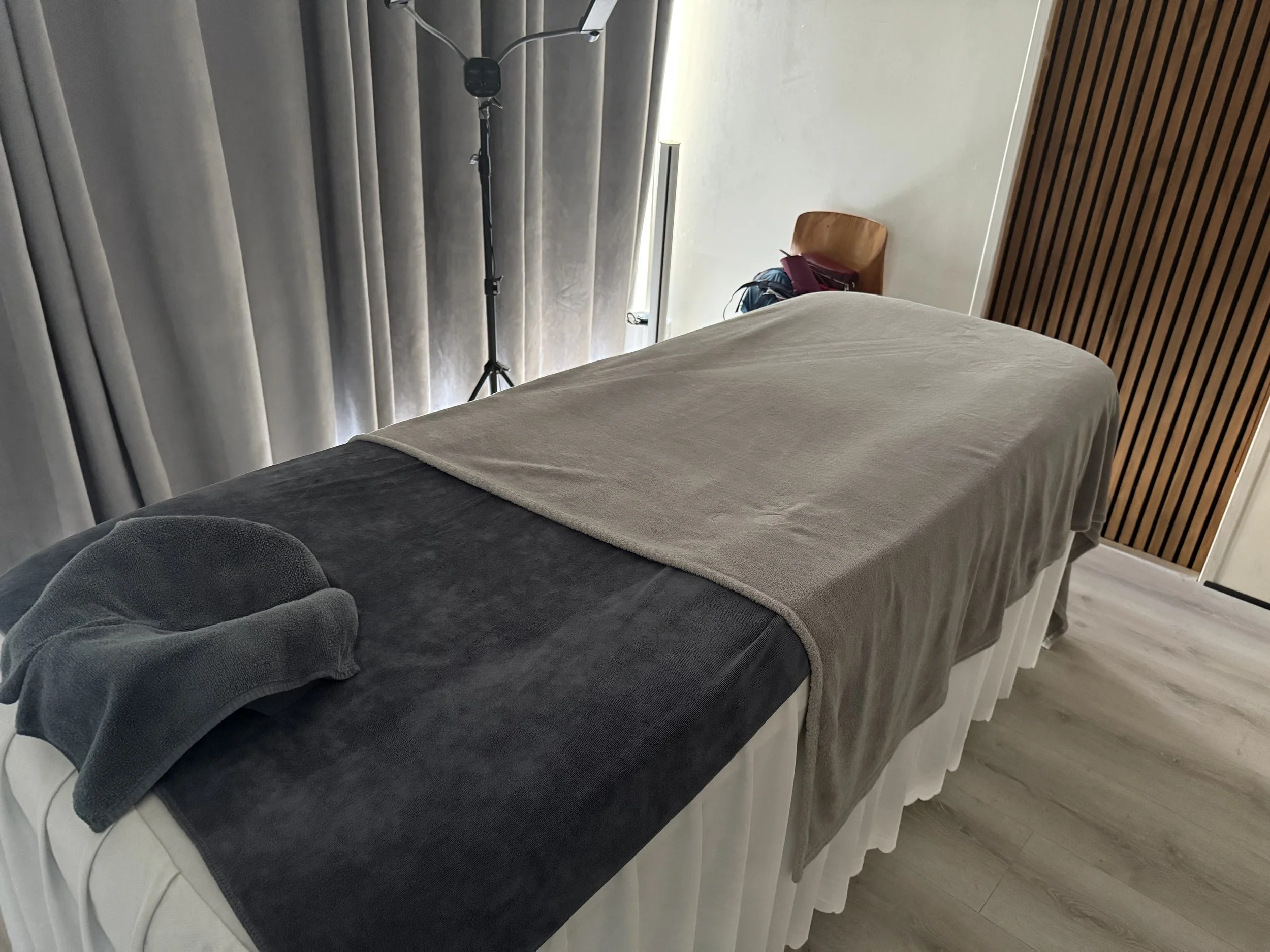 Massage table with a plush blanket over it and a face rest at the top of the table