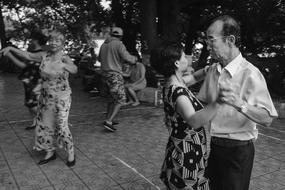 old couple dancing near Hoan kiem lake in Hanoi