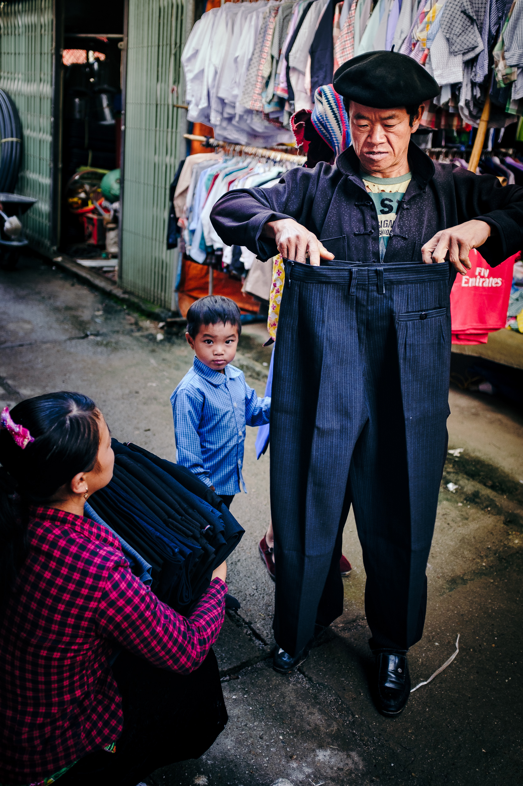  A man measuring the size of his trouser in Dong van market 