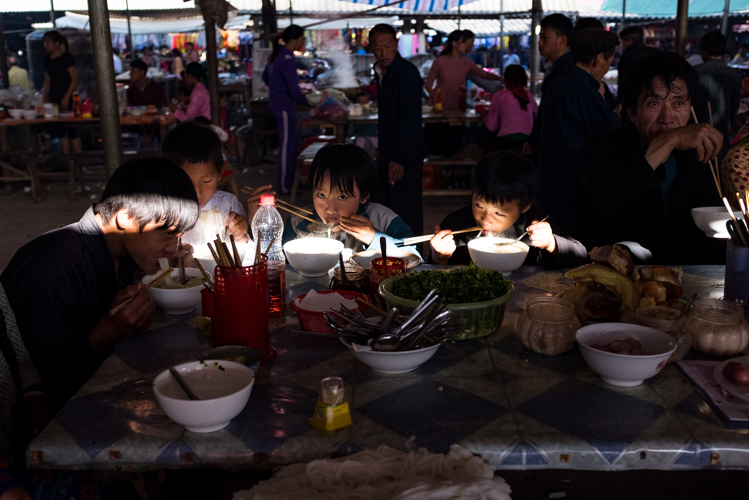  Group of young boys having pho noodles in Dong van market. 