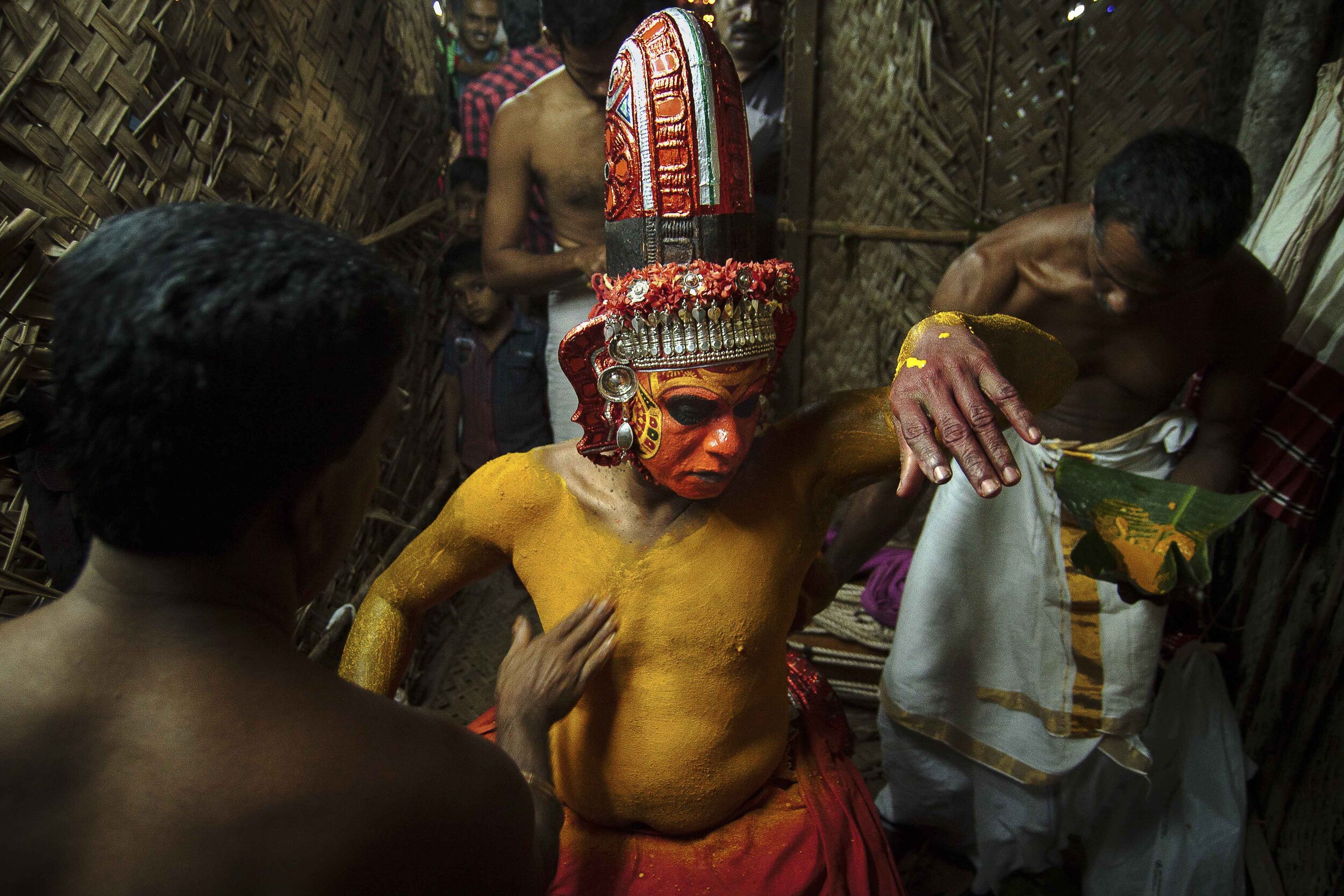  Naturally made dyes are being used to make-up the Theyyam performers.Here few make-up artists are applying turmeric to a performer.Usually there are no dedicated artists for every individual preparation, a make-up artist sometimes becomes a Theyyam 