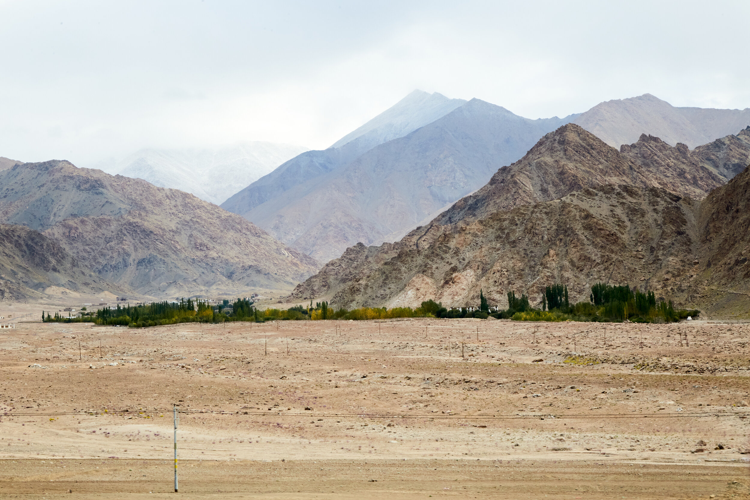  A small village out in a barren land surrounded by hills 