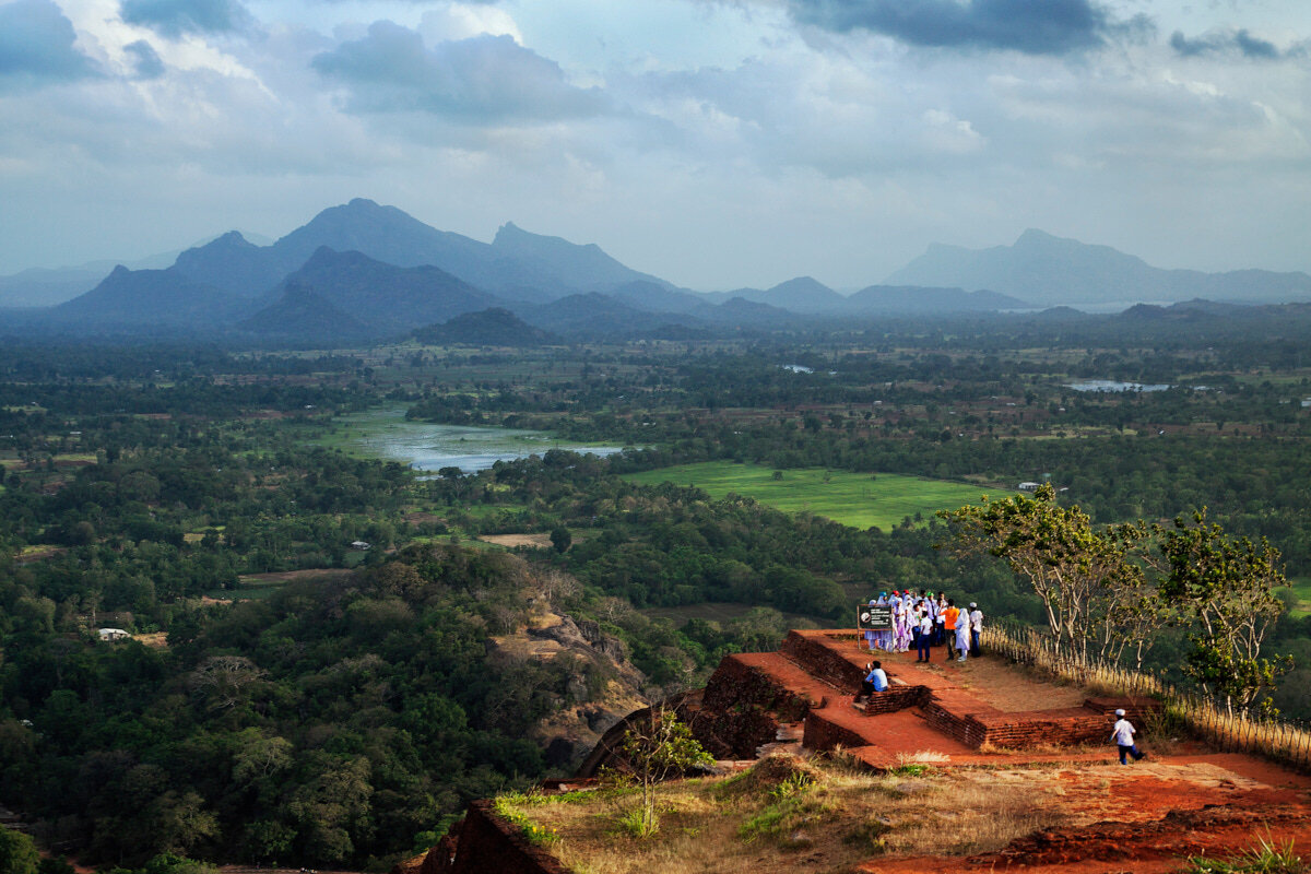  Group of school children standing at the edge of top most part of Sigiriya Rock Fortress with the beautiful landscape in the background at dusk- a Unesco World Heritage site in Sri Lanka 