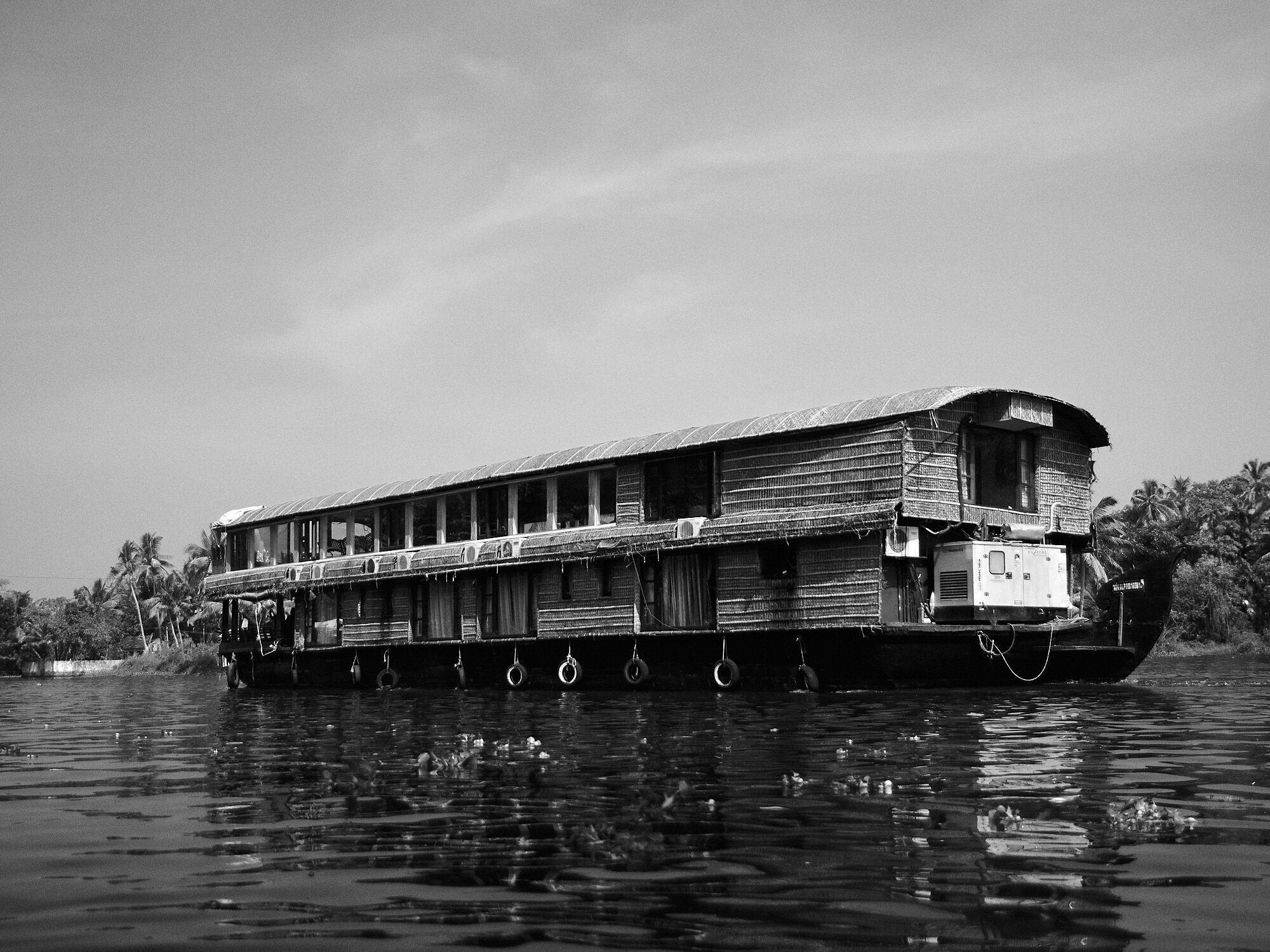 A large houseboat with larger number of rooms and facilities for conferences navigating through the backwaters in Alappuzha, Kerala. 