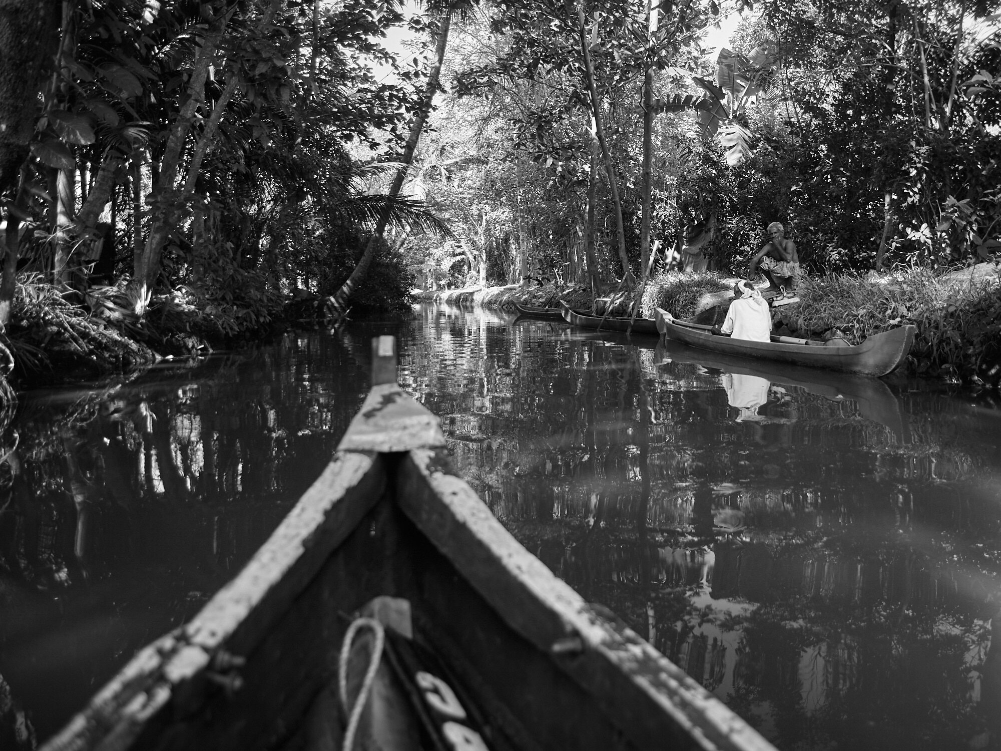  A wooden boat was navigating through the much smaller waterways connecting the smaller villages in Alappuzha, Kerala. 