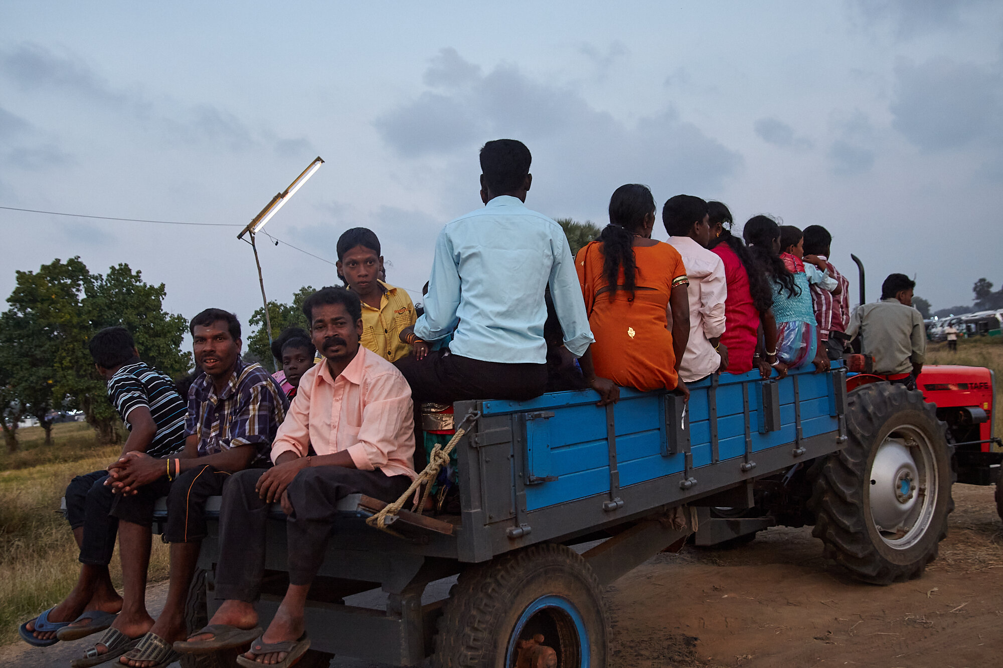  Villagers arriving to the temple in trailers connected to the tractors. This is a well established and cost effective method to transport large number of people in the region. 