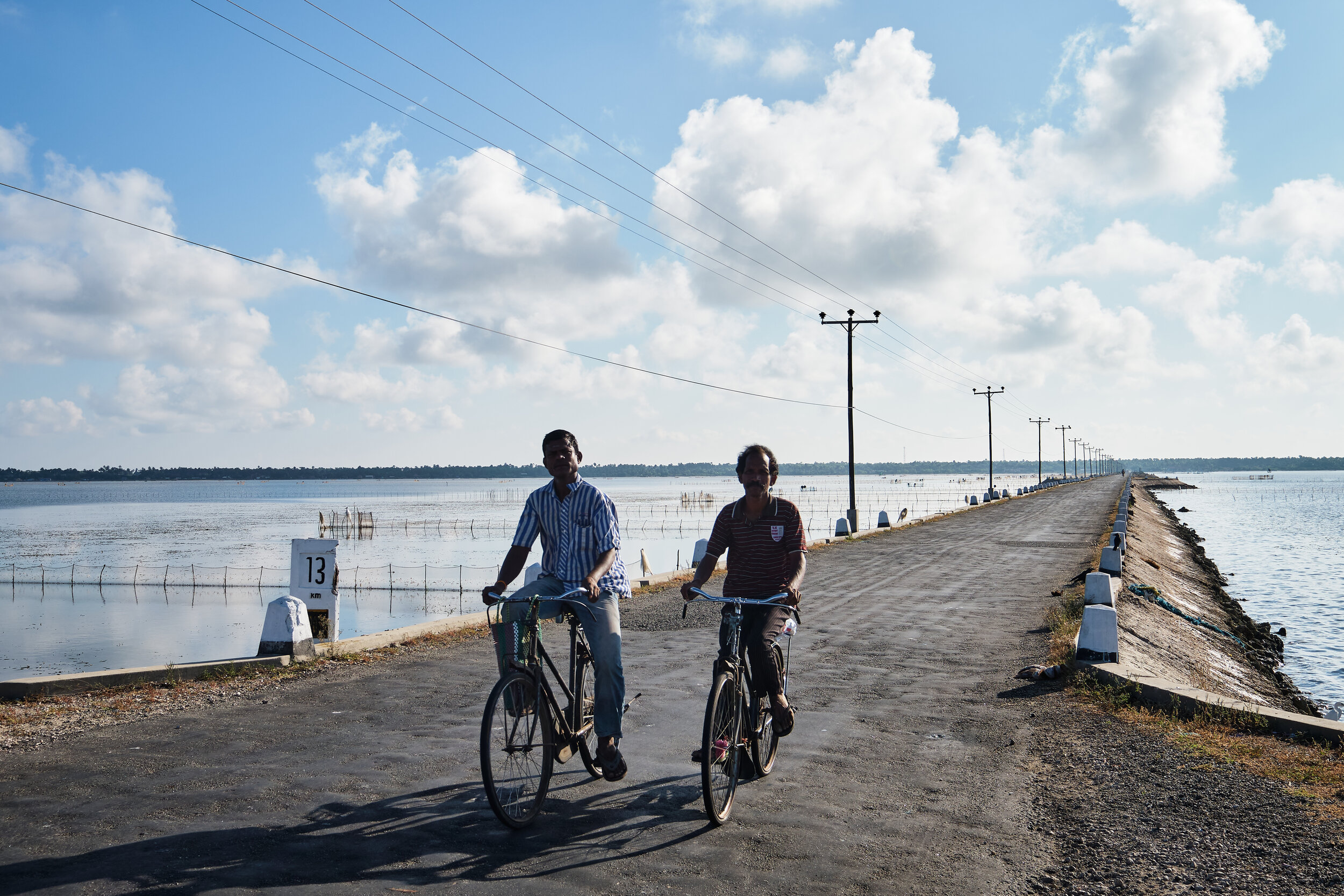  cyclists  crossing the mainlands through the sea-road. 