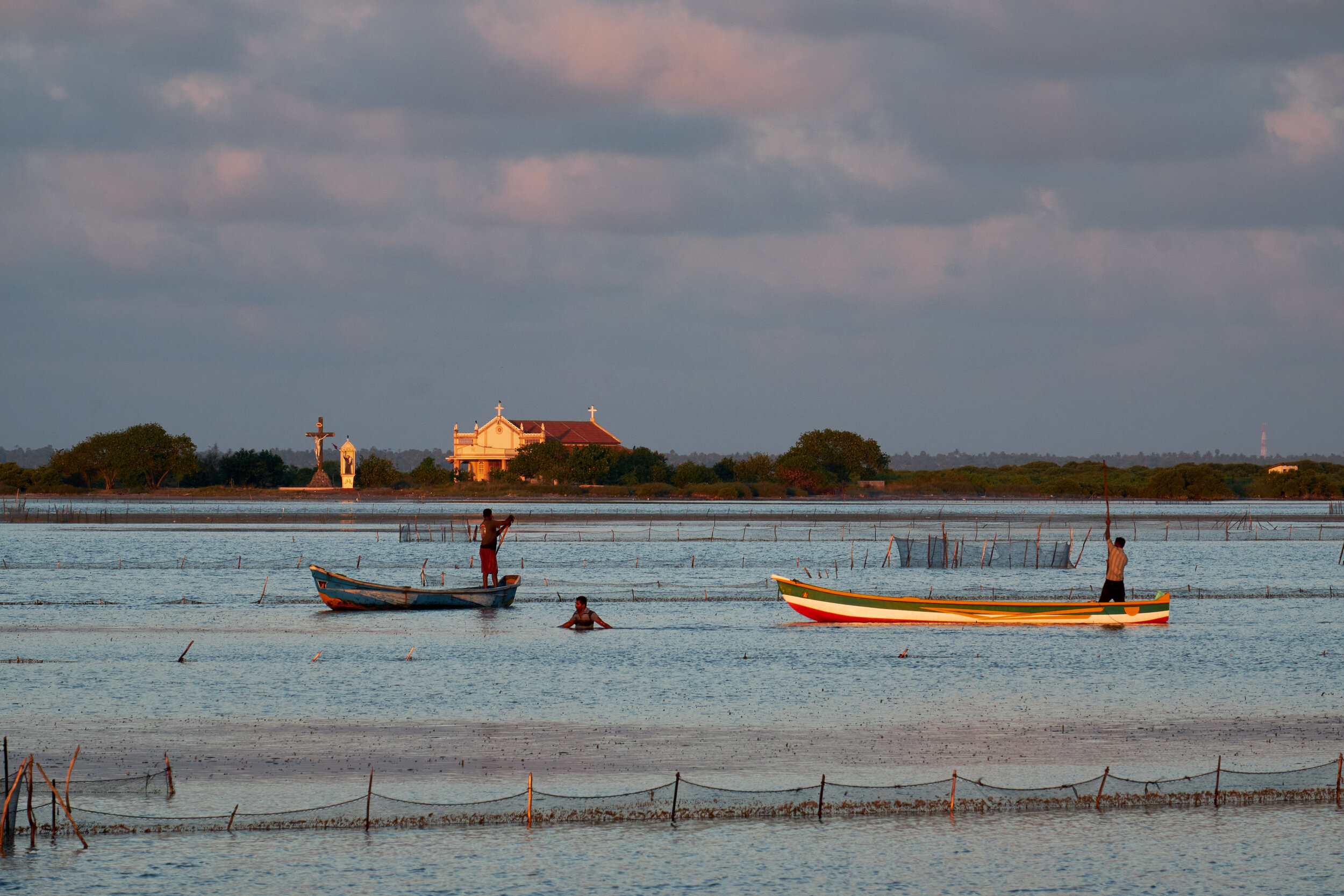  A group of fishermen navigating around the tightly placed fishing system. 