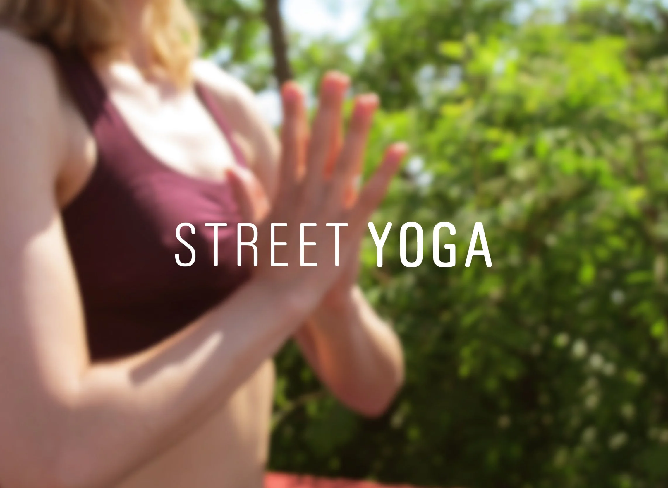 blurred photo of yogi angeli mudra with logo STREET YOGA in white above