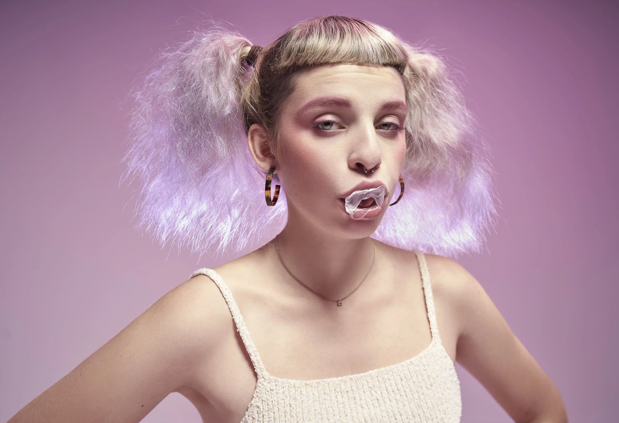 Girl on a pink background chewing gum
